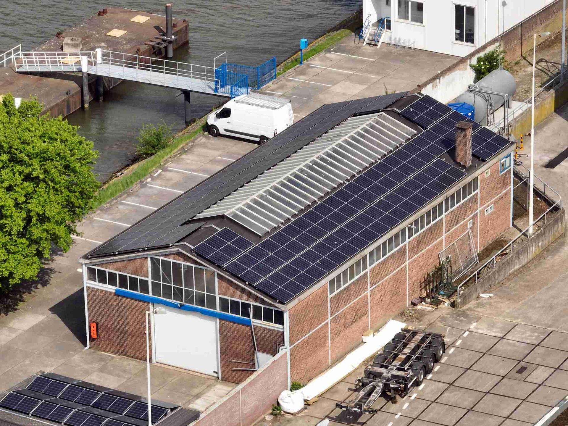 Een luchtfoto van een gebouw met zonnepanelen op het dak