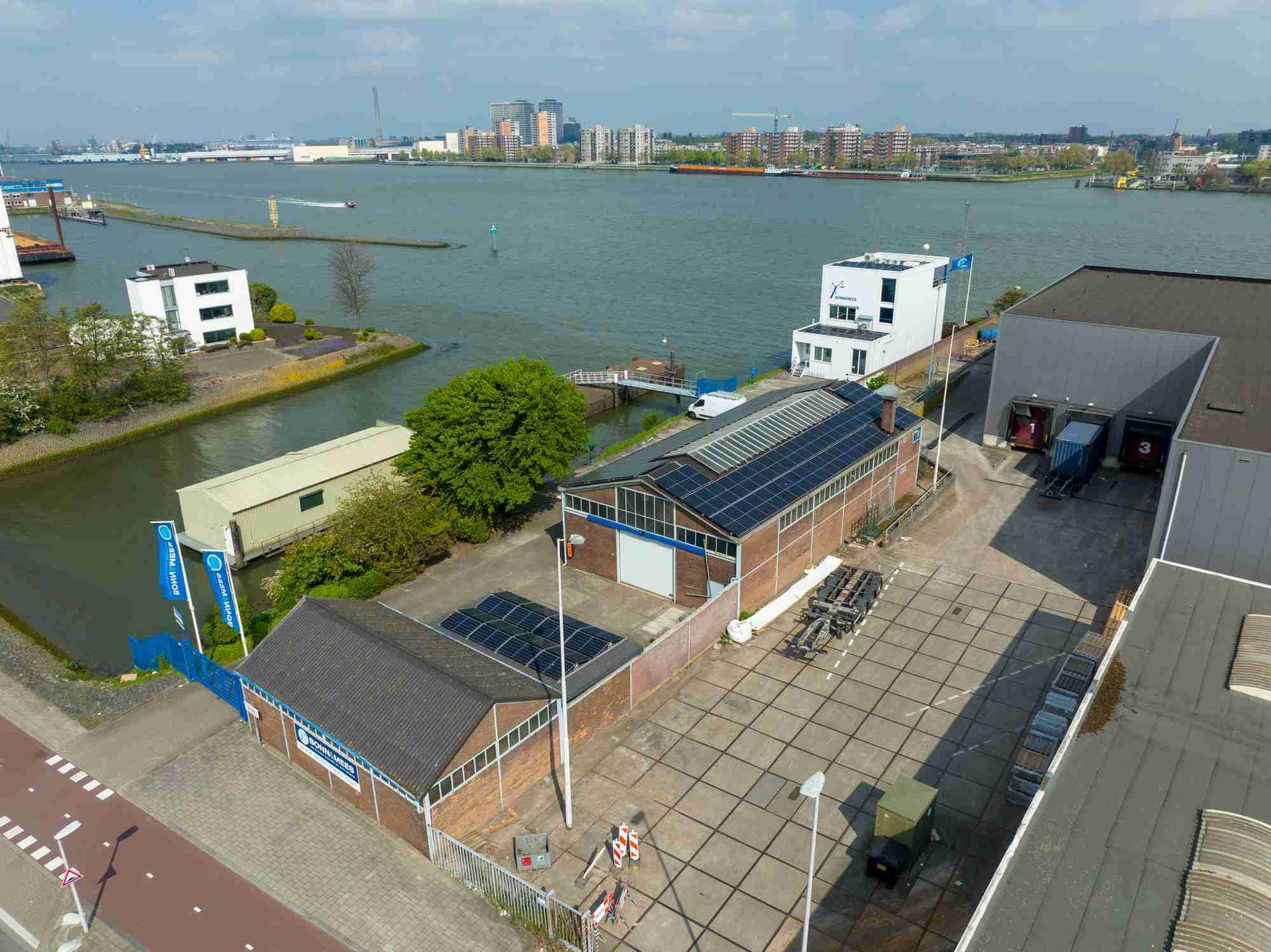 Een luchtfoto van een gebouw naast een waterpartij.