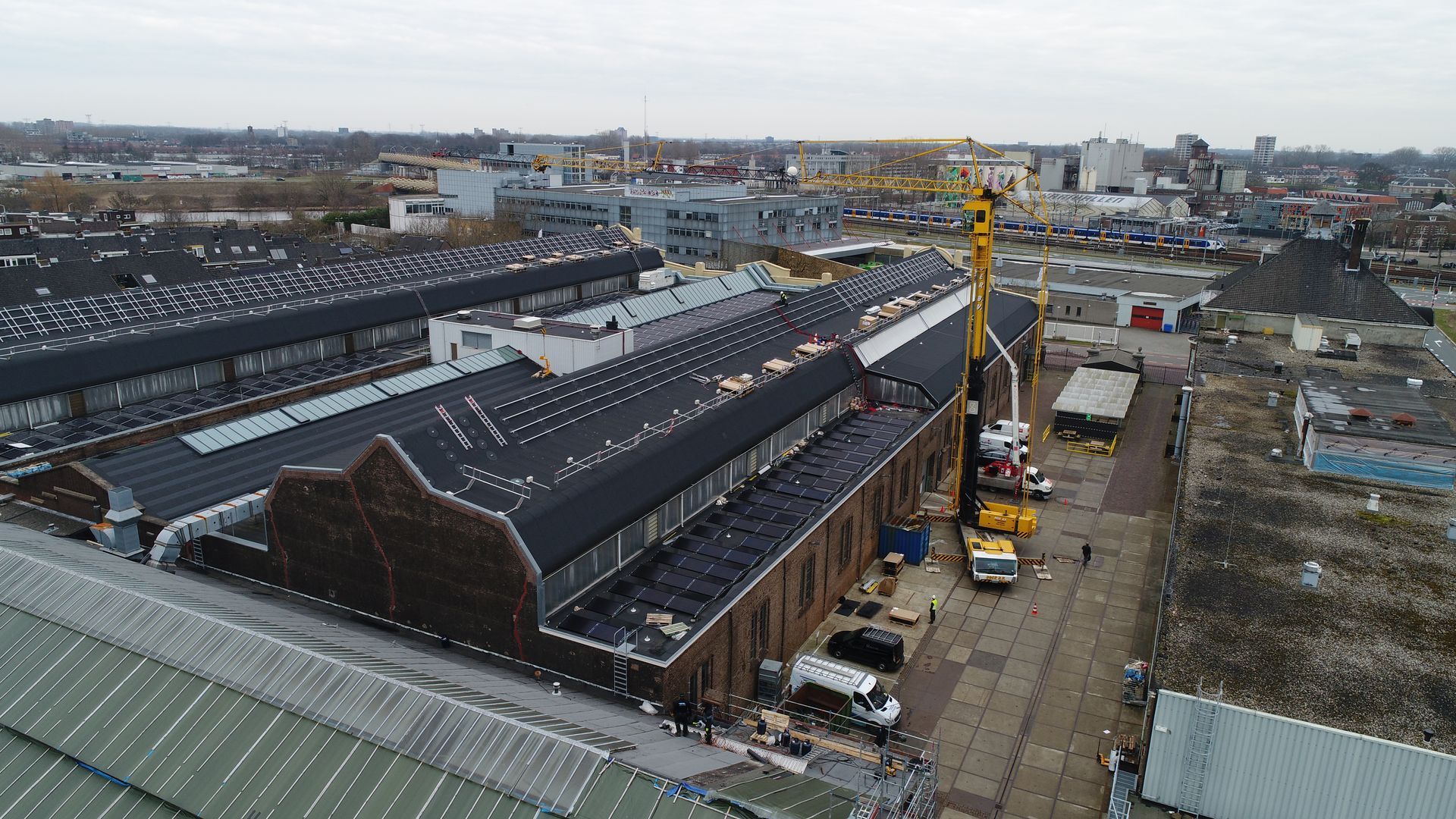 Een luchtfoto van een groot gebouw met daarop een kraan.