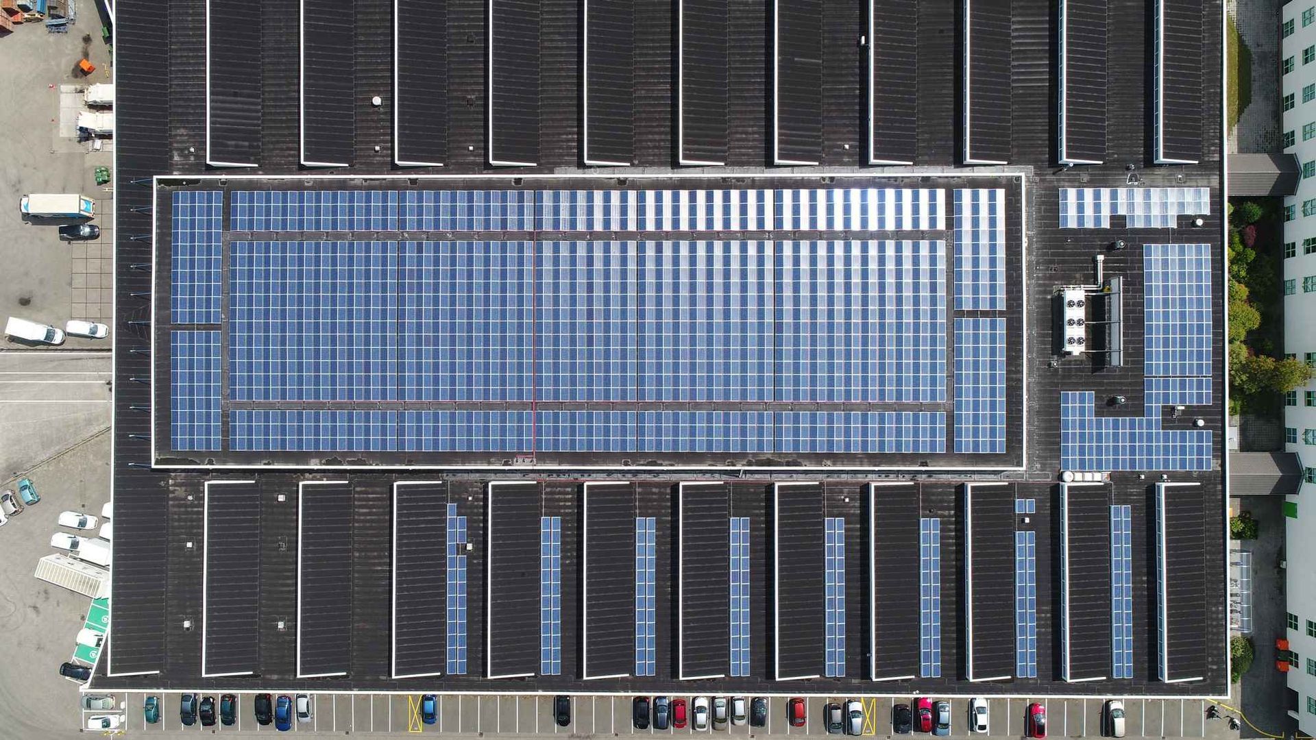 Een luchtfoto van een groot gebouw met zonnepanelen op het dak