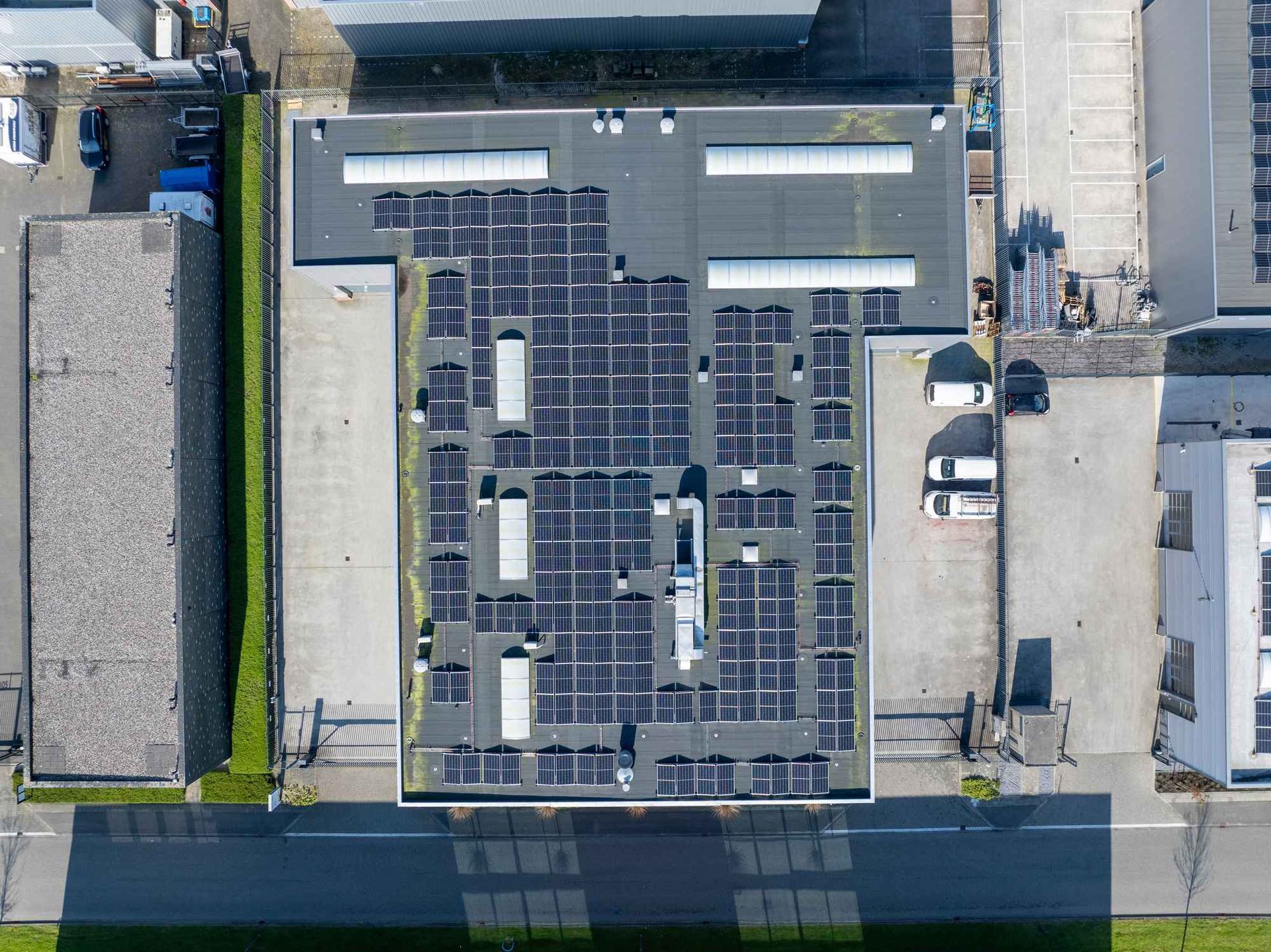 Een luchtfoto van een gebouw met zonnepanelen op het dak.