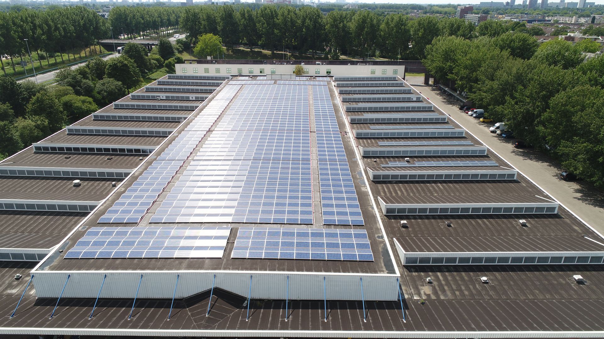 Een groot gebouw met veel zonnepanelen op het dak
