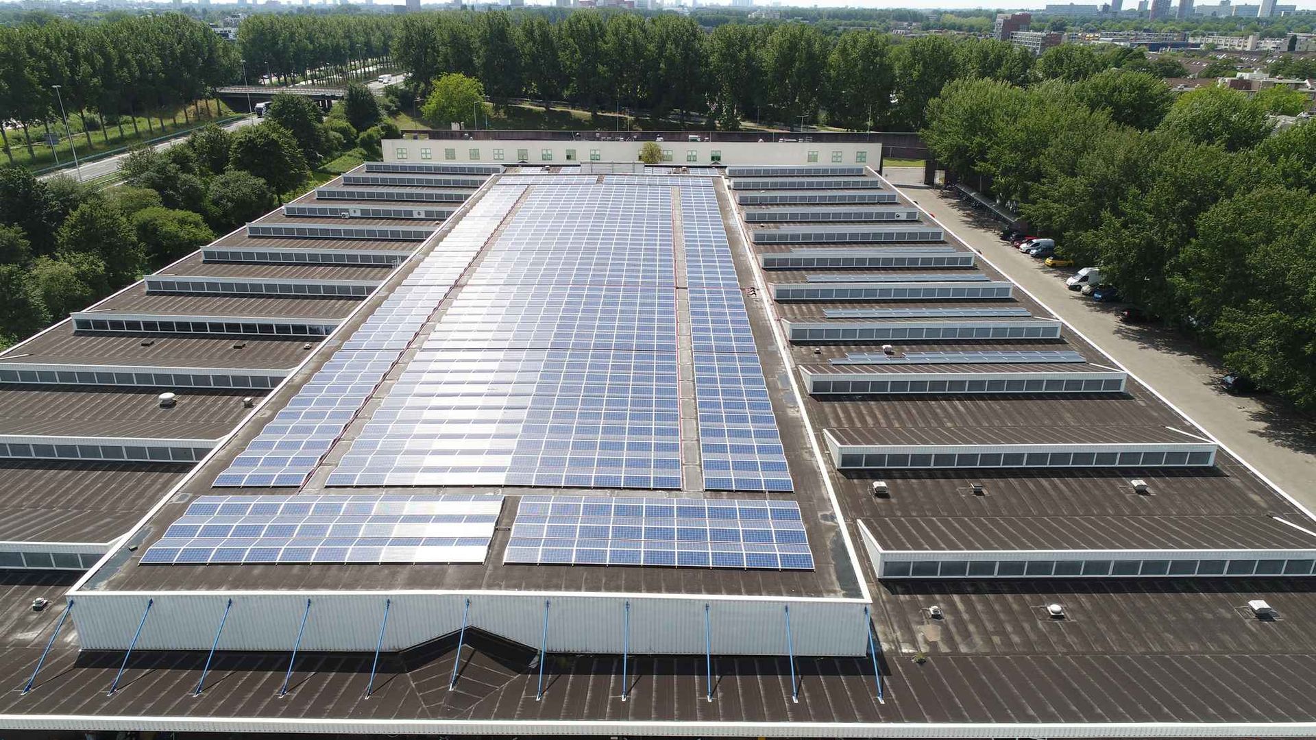 Een groot gebouw met veel zonnepanelen op het dak