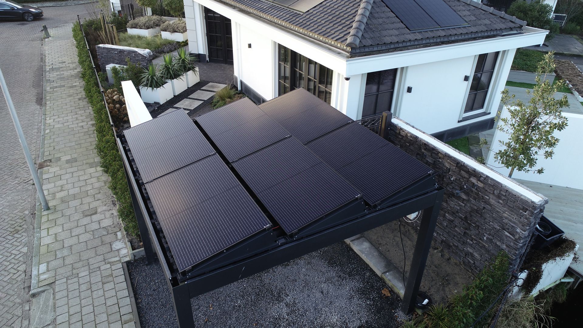 Een luchtfoto van een huis met zonnepanelen op het dak.