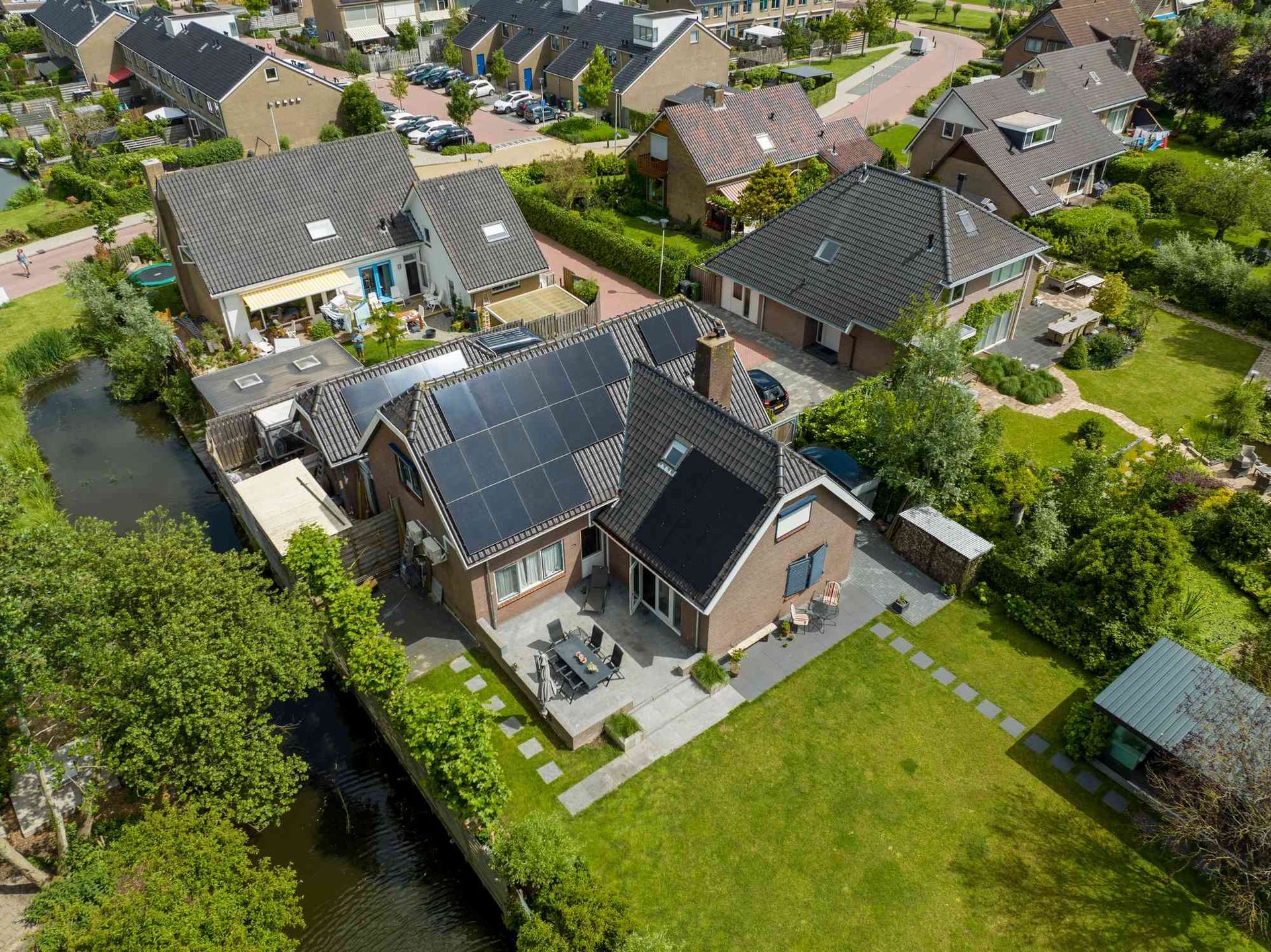 Een luchtfoto van een huis met zonnepanelen op het dak.