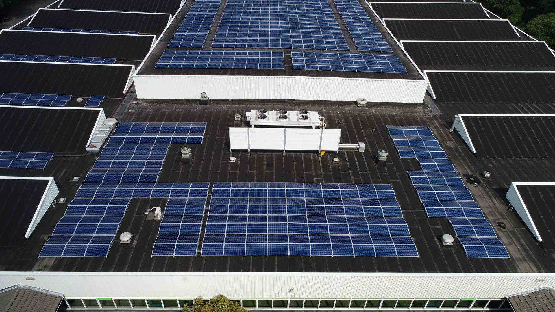 Een groot gebouw met veel zonnepanelen op het dak