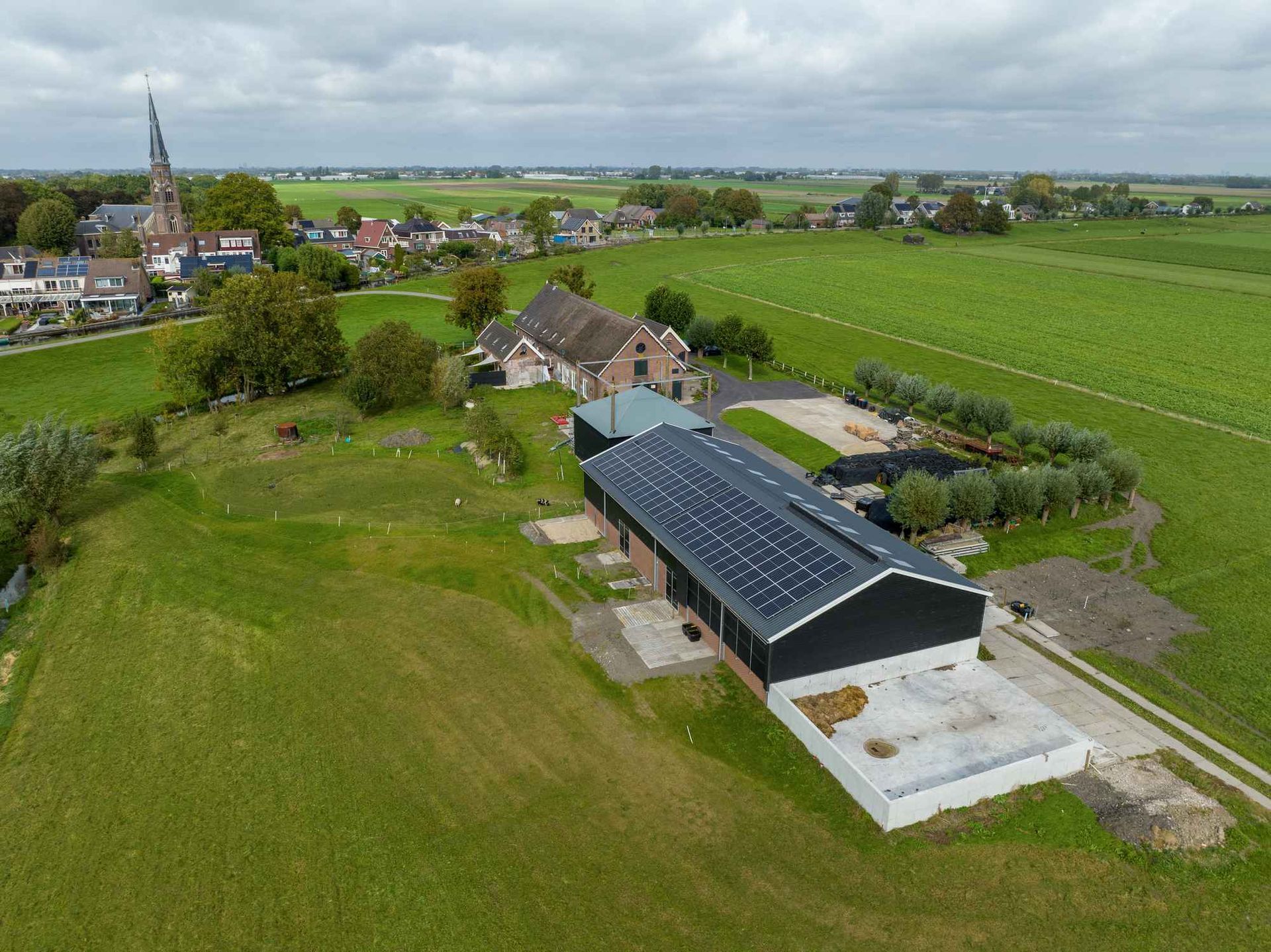 Een luchtfoto van een boerderij met zonnepanelen op het dak.