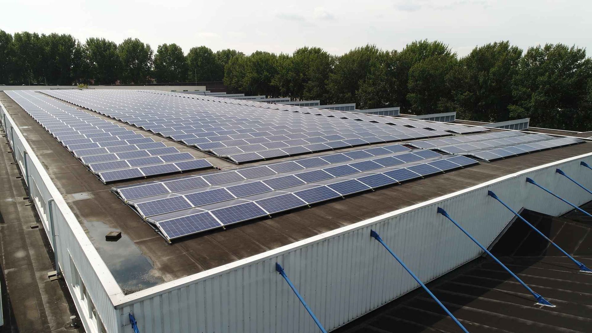 Er liggen veel zonnepanelen op het dak van een gebouw.