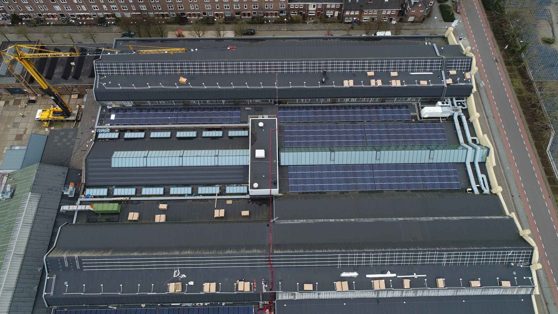 Een luchtfoto van een groot gebouw met zonnepanelen op het dak.