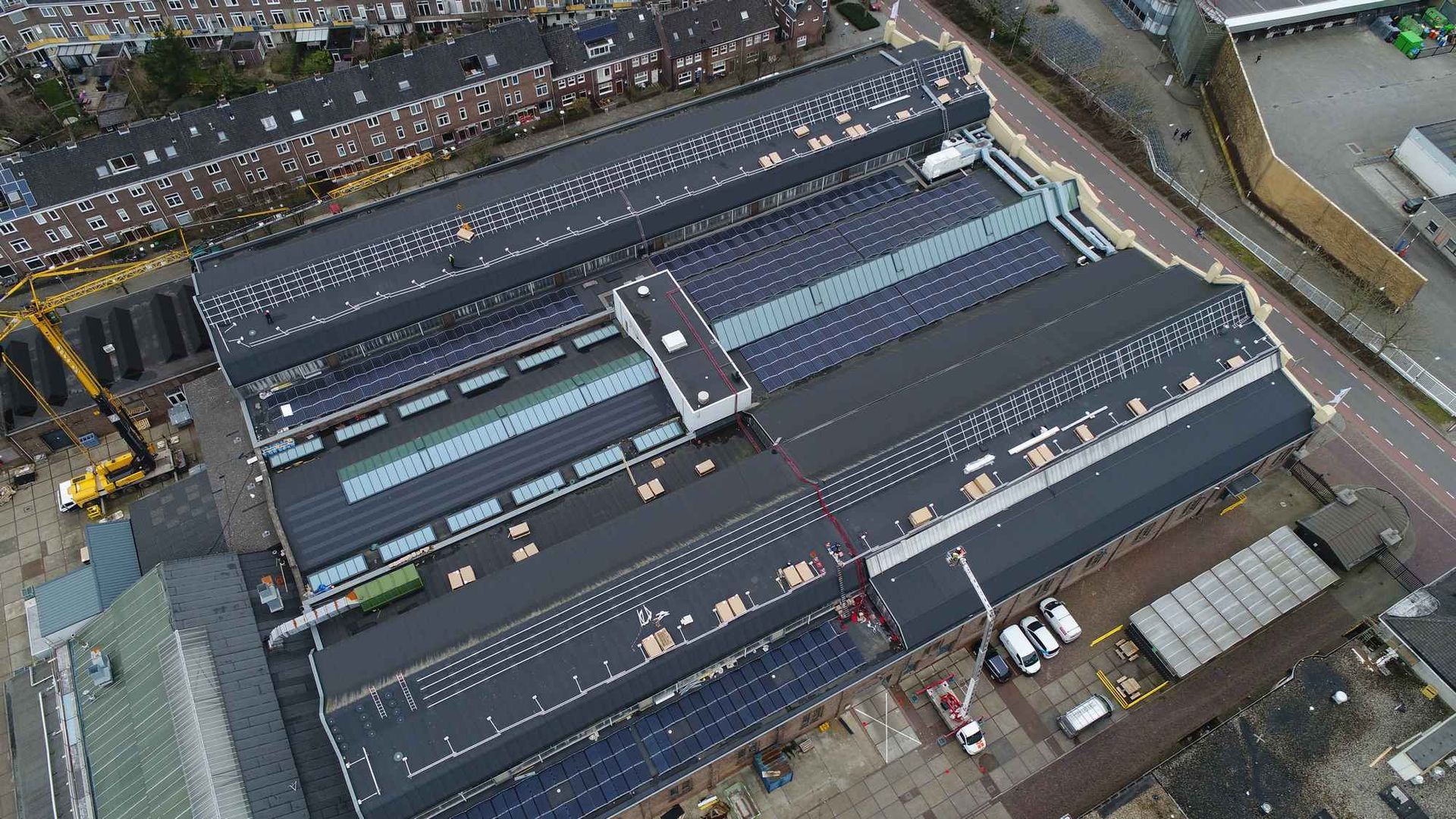 Een luchtfoto van een groot gebouw met zonnepanelen op het dak.