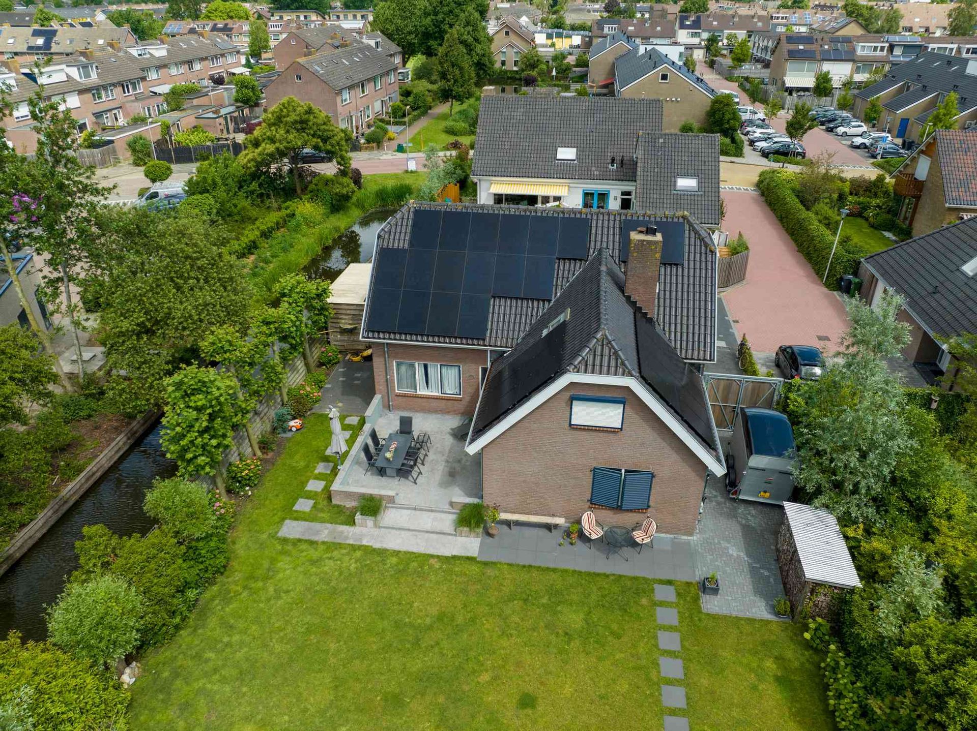 Een luchtfoto van een huis met zonnepanelen op het dak
