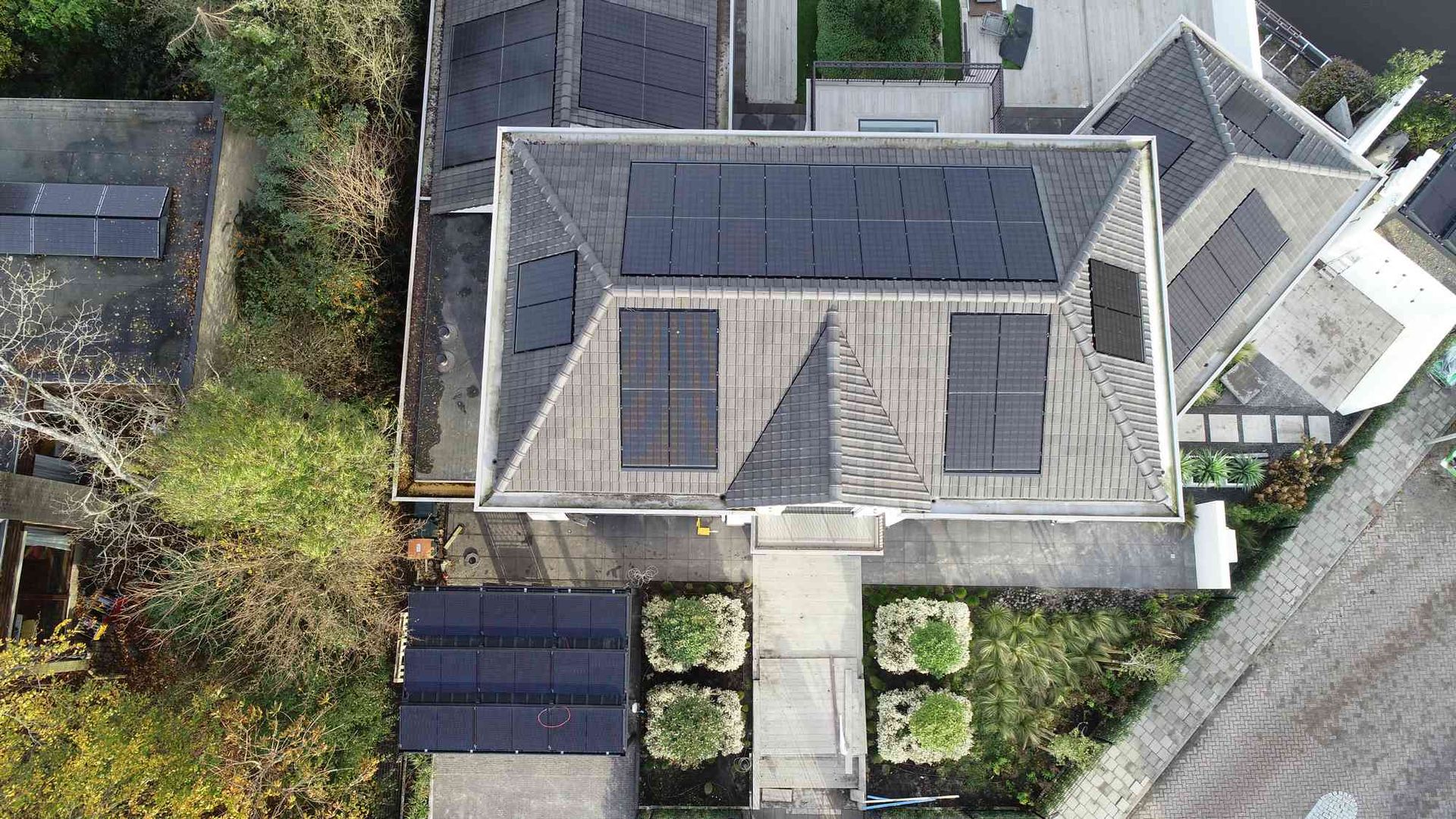 Een luchtfoto van een huis met zonnepanelen op het dak.