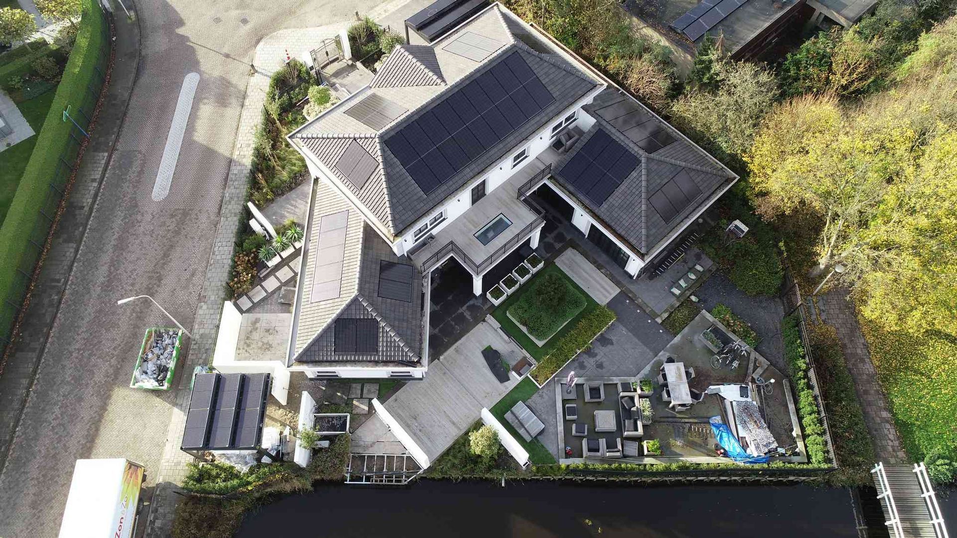 Een luchtfoto van een groot huis met zonnepanelen op het dak.