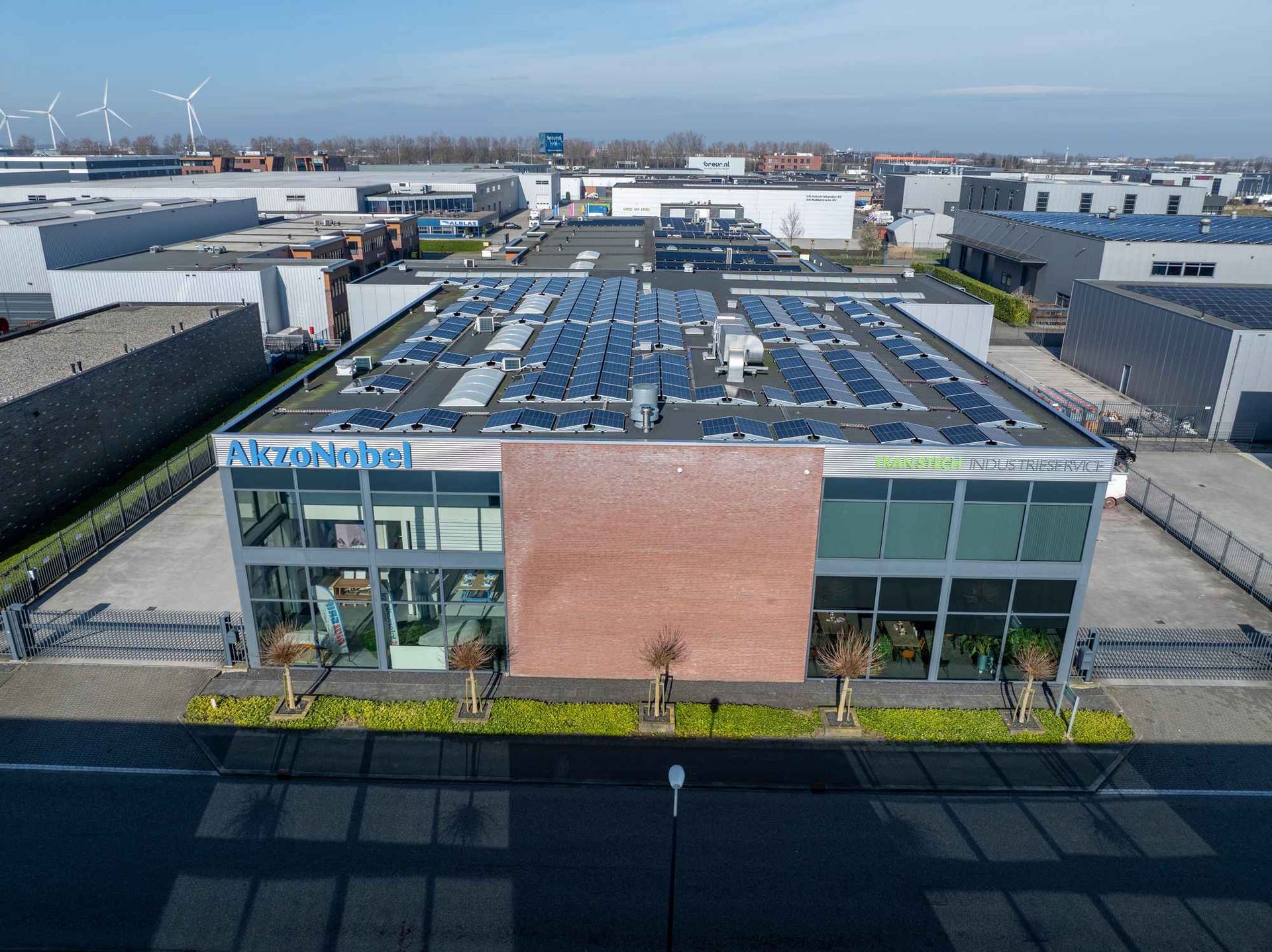 Een luchtfoto van een groot gebouw met zonnepanelen op het dak.