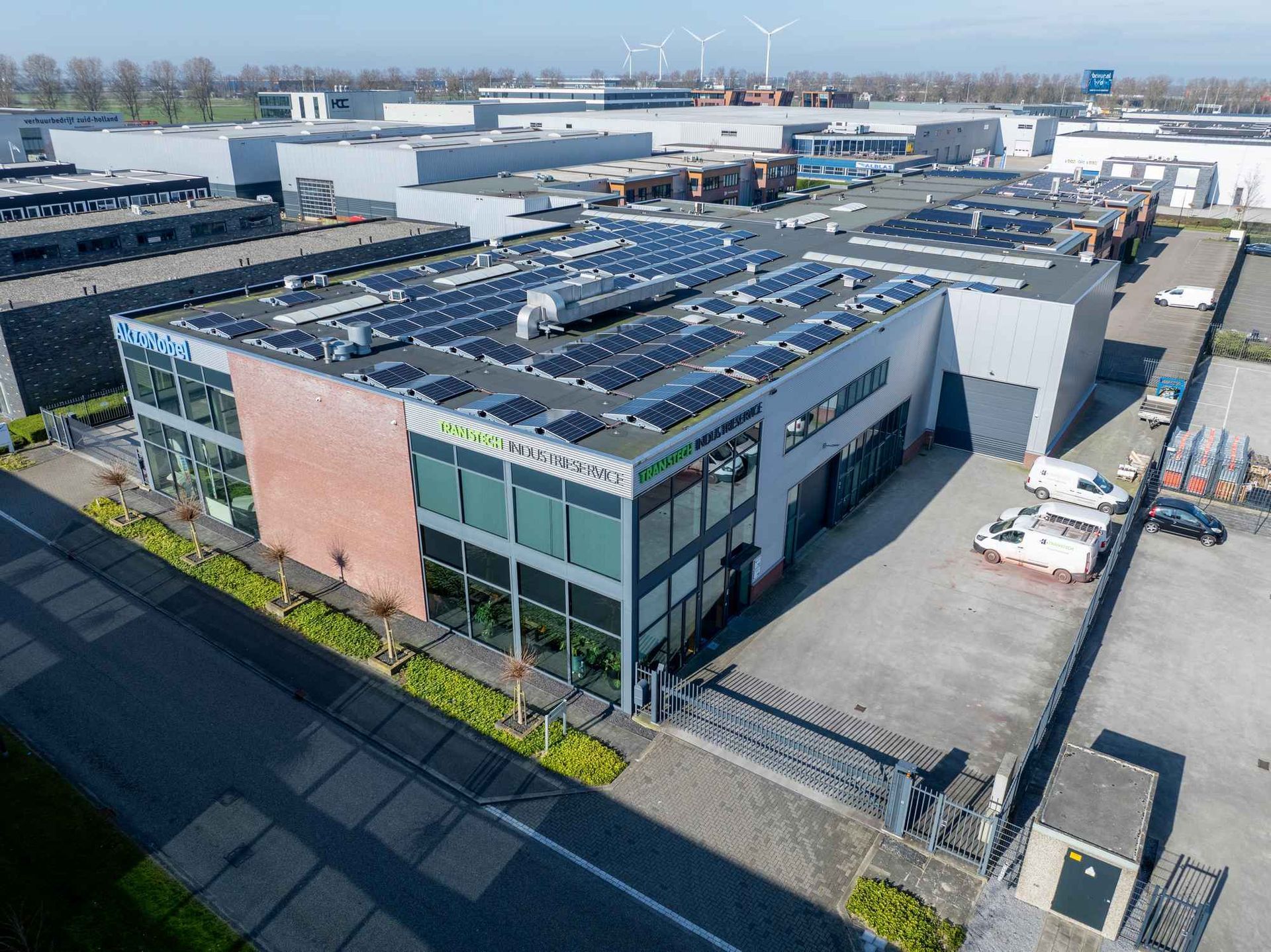 Een luchtfoto van een groot gebouw met zonnepanelen op het dak.