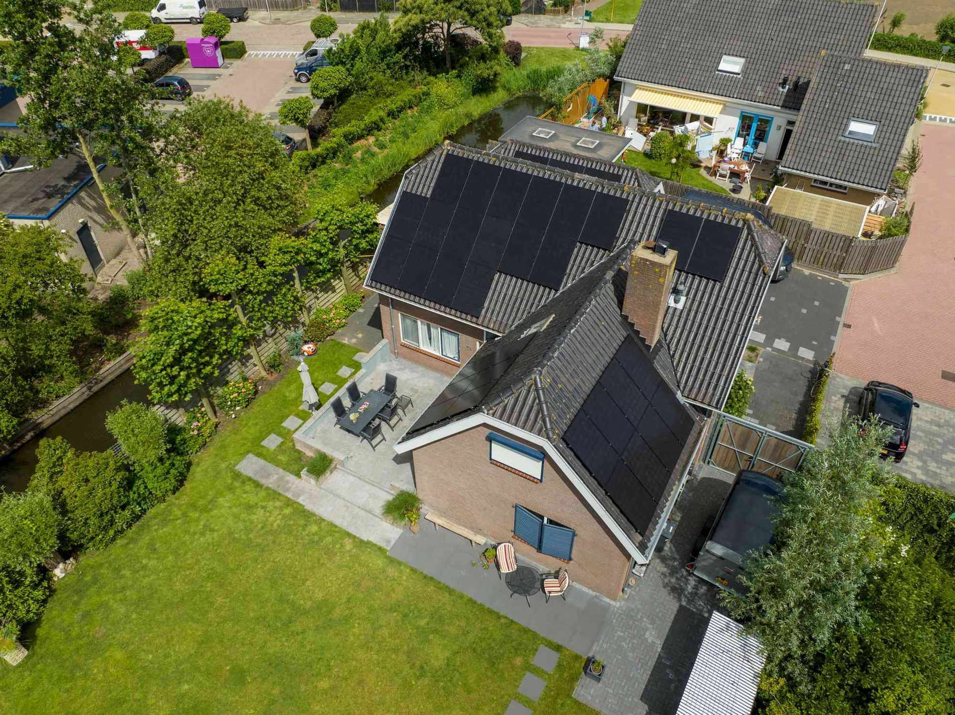 Een luchtfoto van een huis met zonnepanelen op het dak.