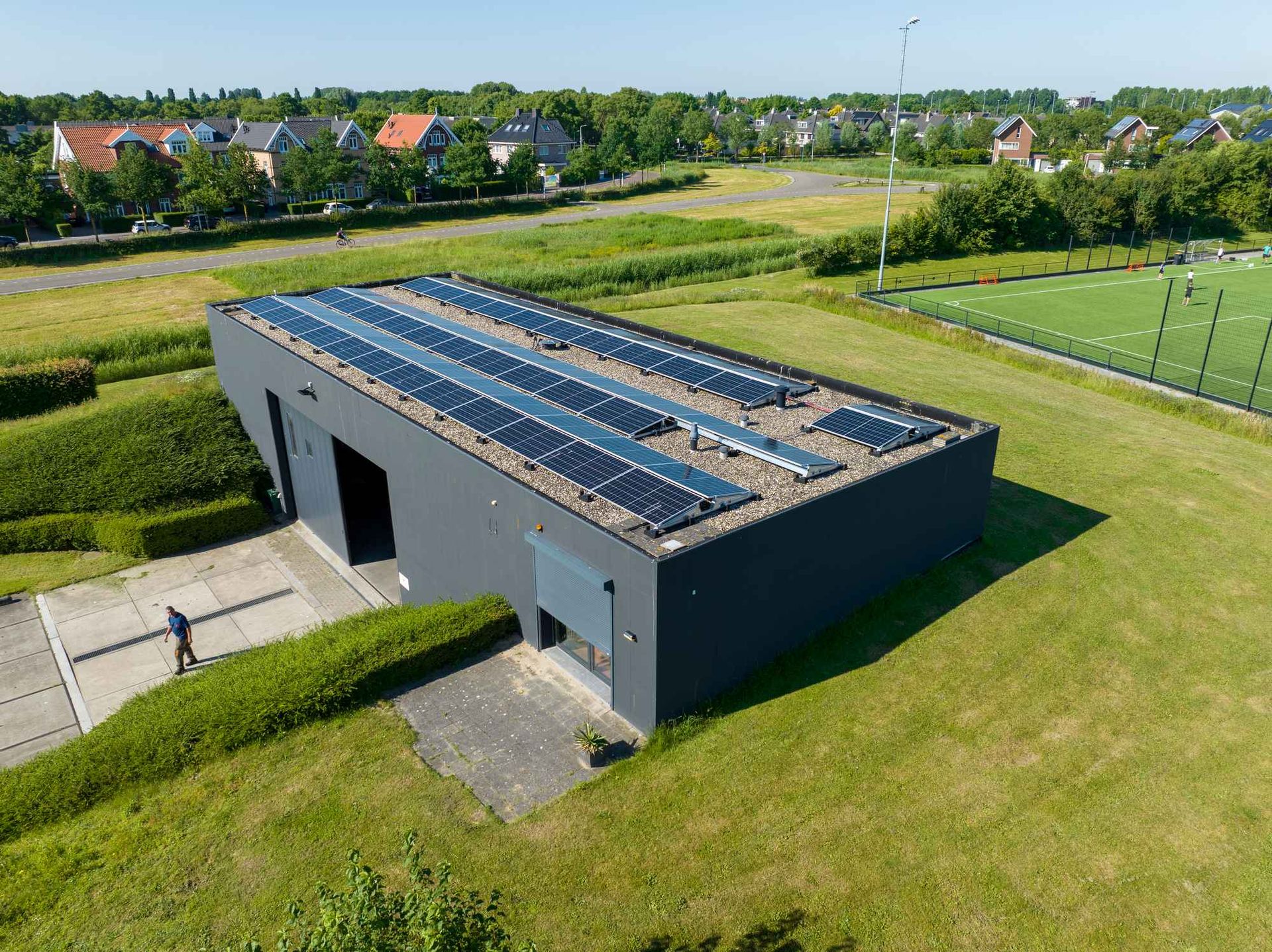 Een luchtfoto van een gebouw met zonnepanelen op het dak