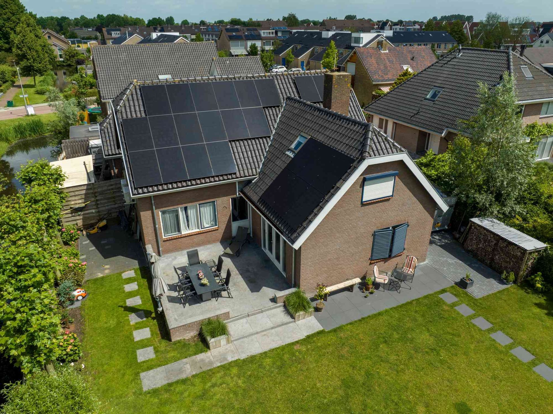 Een luchtfoto van een huis met zonnepanelen op het dak.
