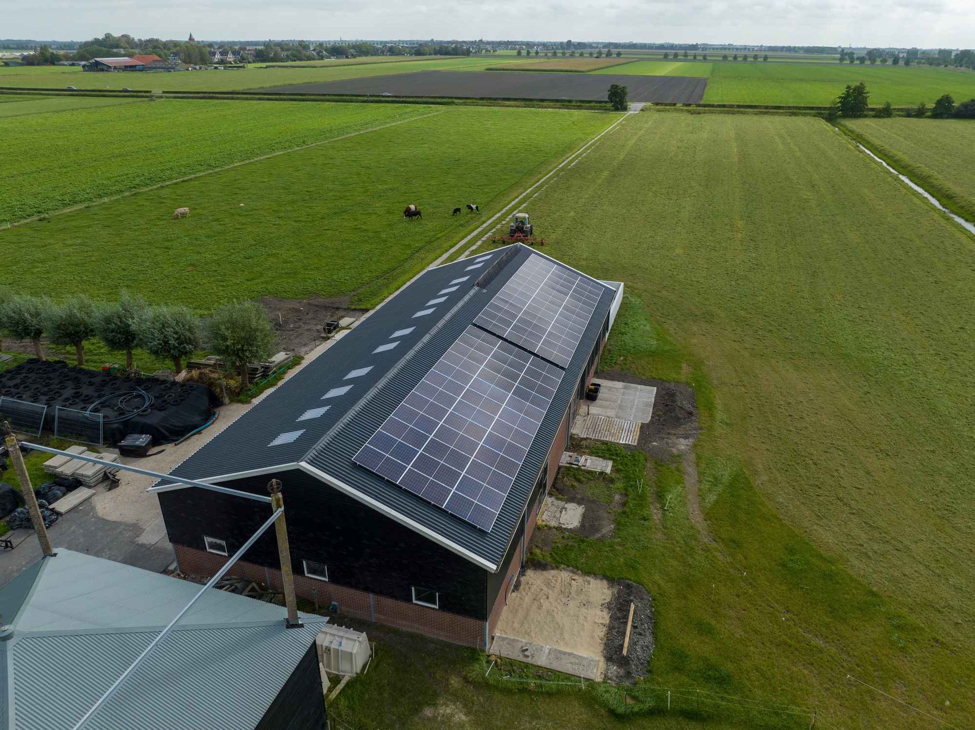 Een luchtfoto van een boerderij met zonnepanelen op het dak.