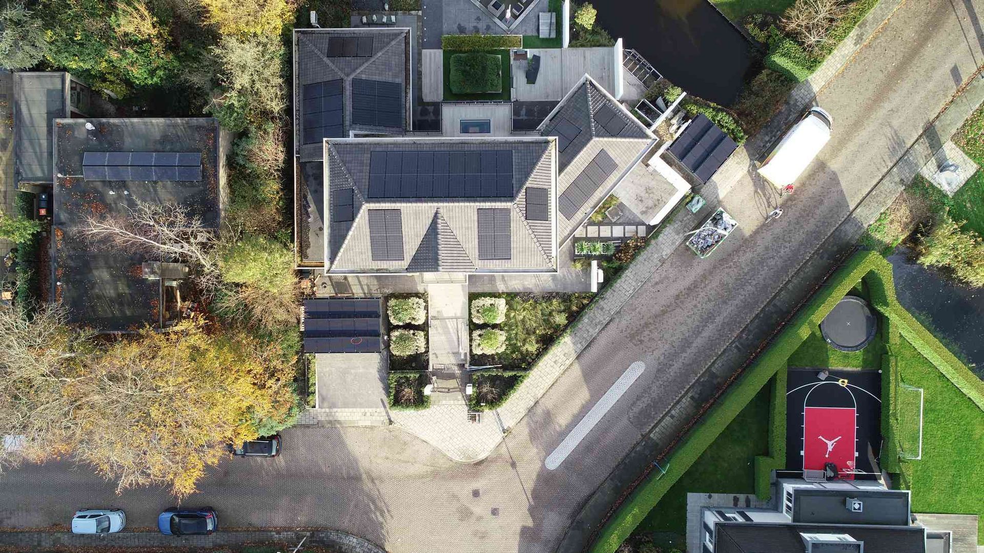 Een luchtfoto van een huis met zonnepanelen op het dak.