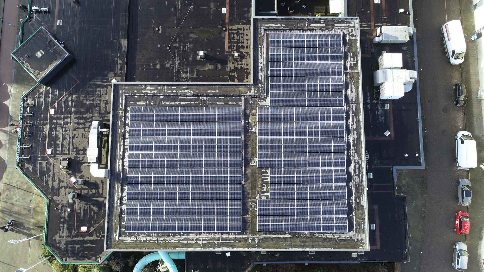 Een luchtfoto van een gebouw met zonnepanelen op het dak