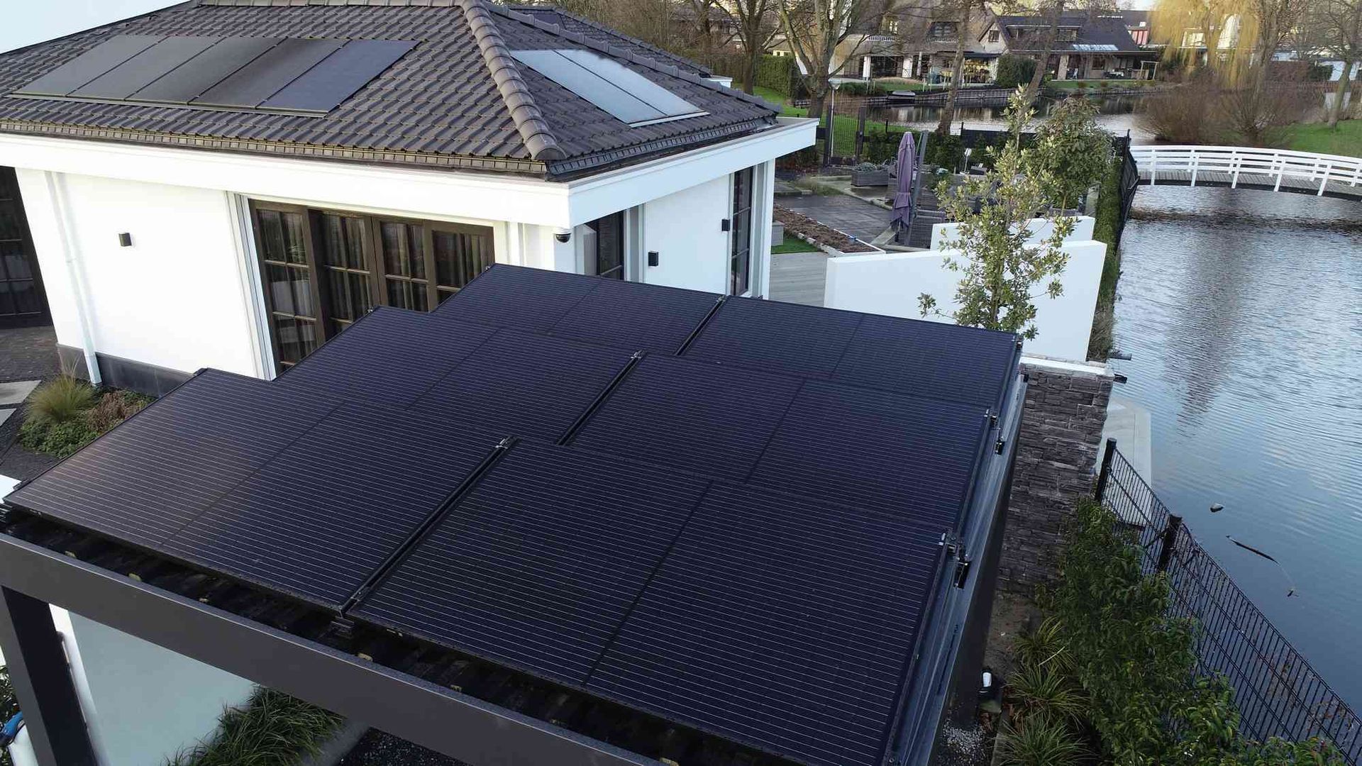 Een luchtfoto van een huis met zonnepanelen op het dak.