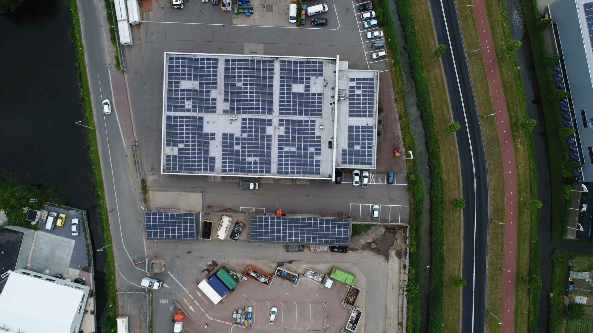 Een luchtfoto van een gebouw met zonnepanelen op het dak.