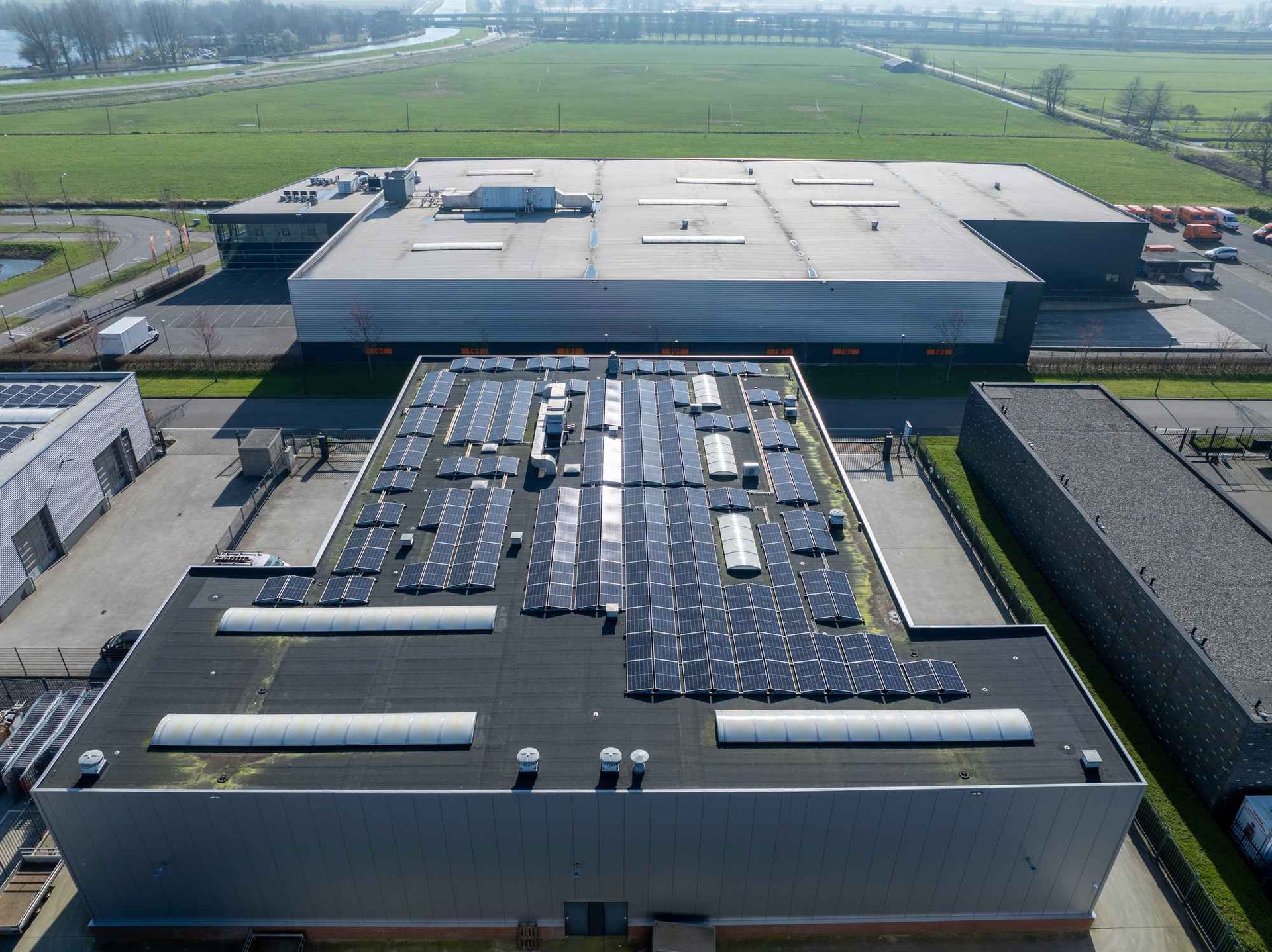 Een luchtfoto van een groot gebouw met zonnepanelen op het dak.