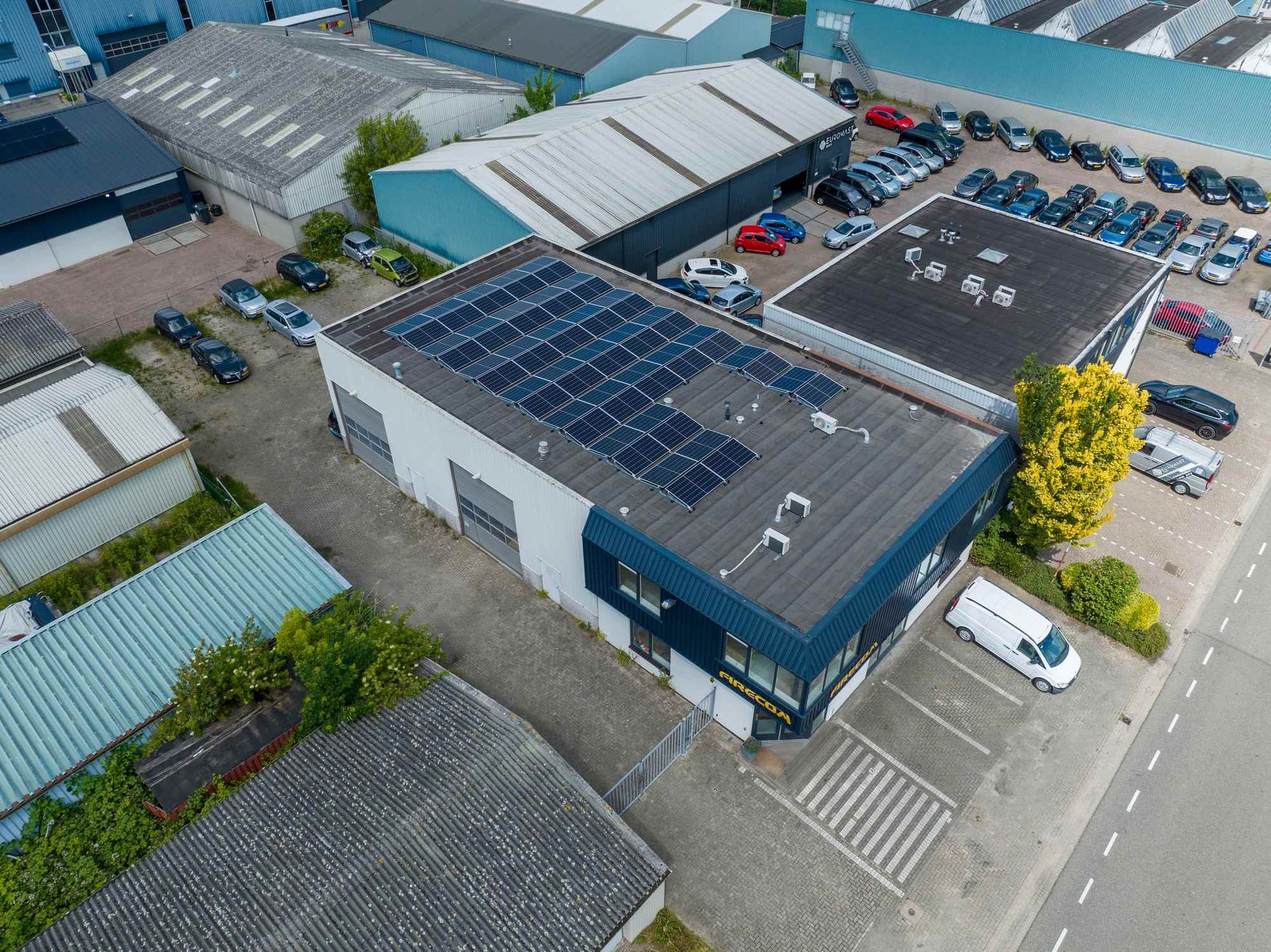 Een luchtfoto van een gebouw met zonnepanelen op het dak.