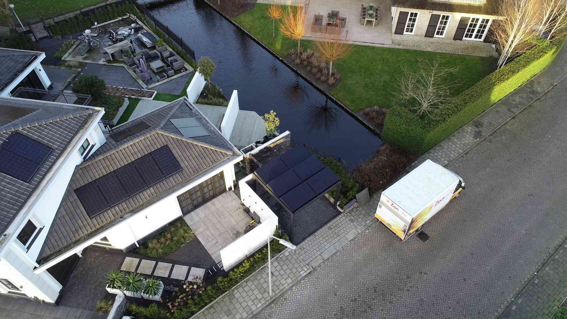 Een luchtfoto van een huis met zonnepanelen op het dak.