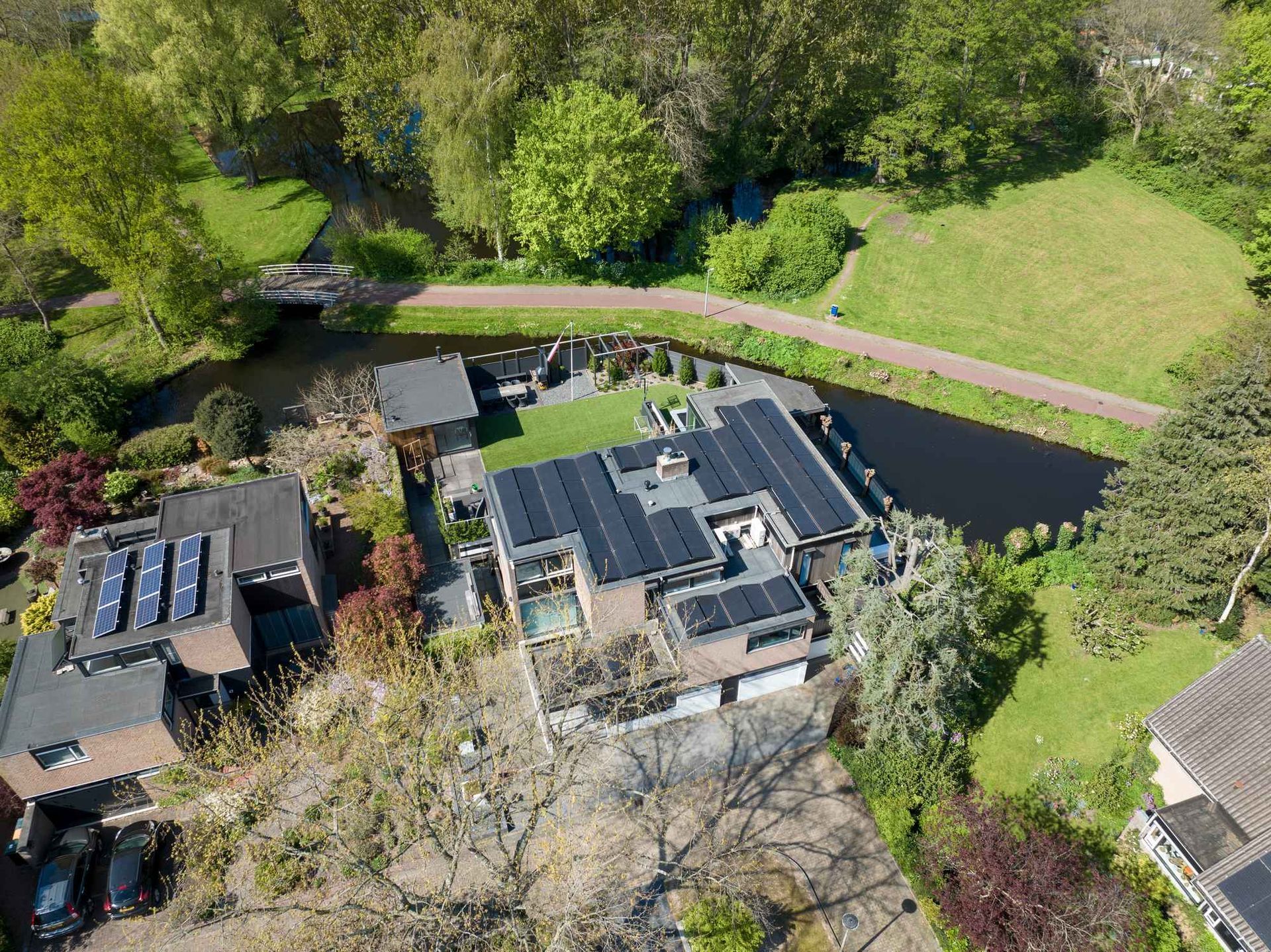 Een luchtfoto van een huis met zonnepanelen op het dak.