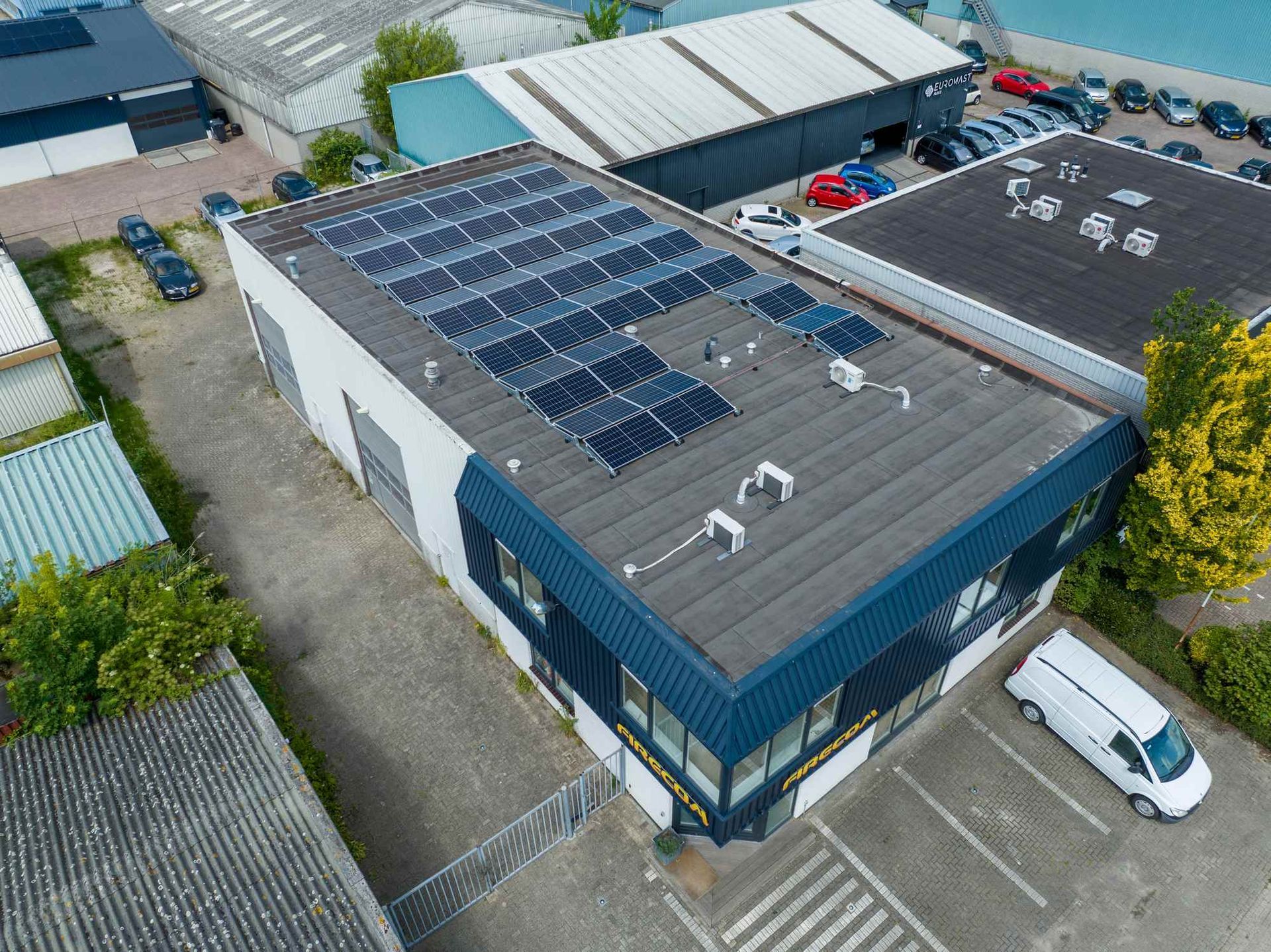 Een luchtfoto van een gebouw met zonnepanelen op het dak.