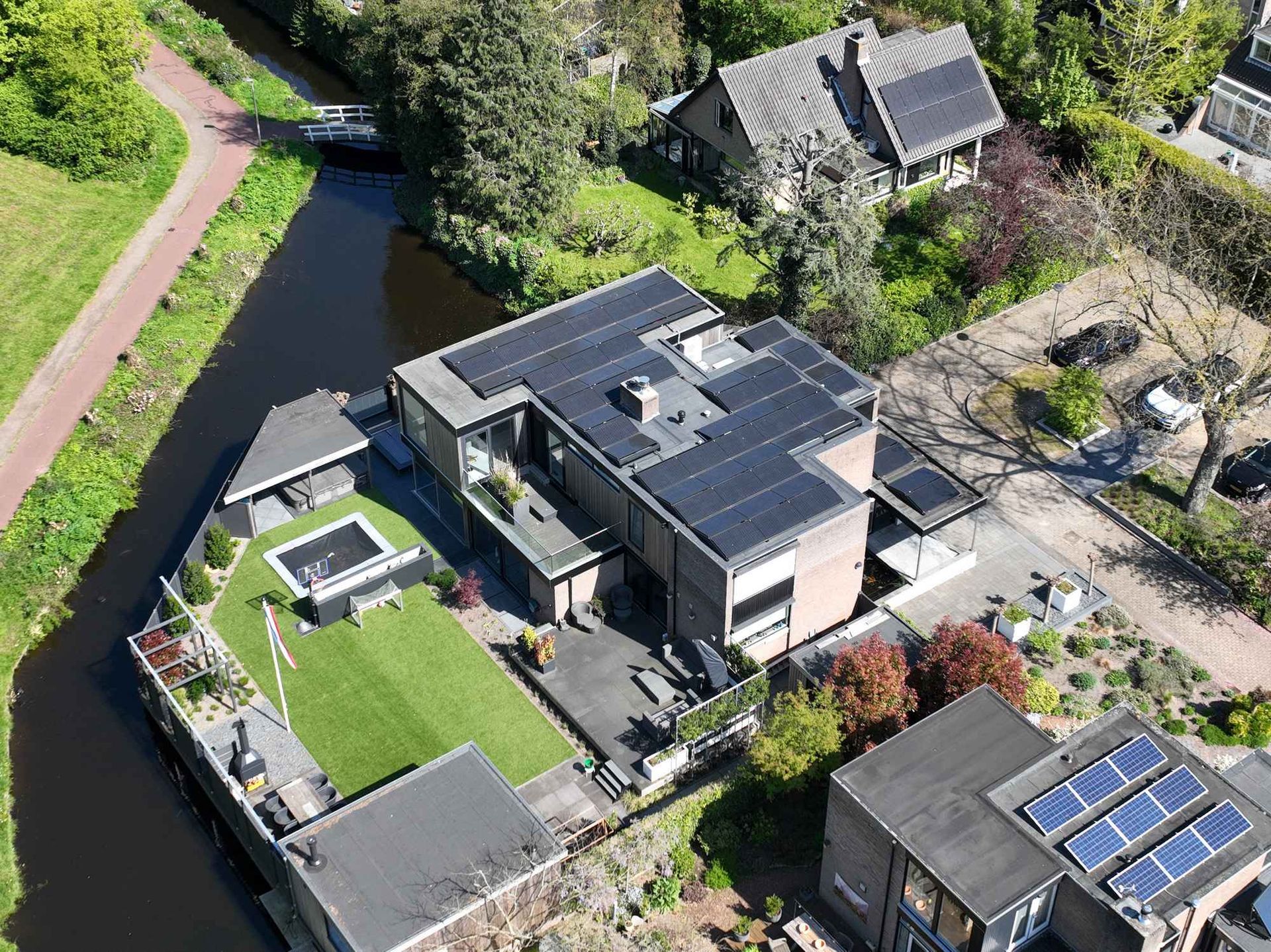 Een luchtfoto van een huis met zonnepanelen op het dak.