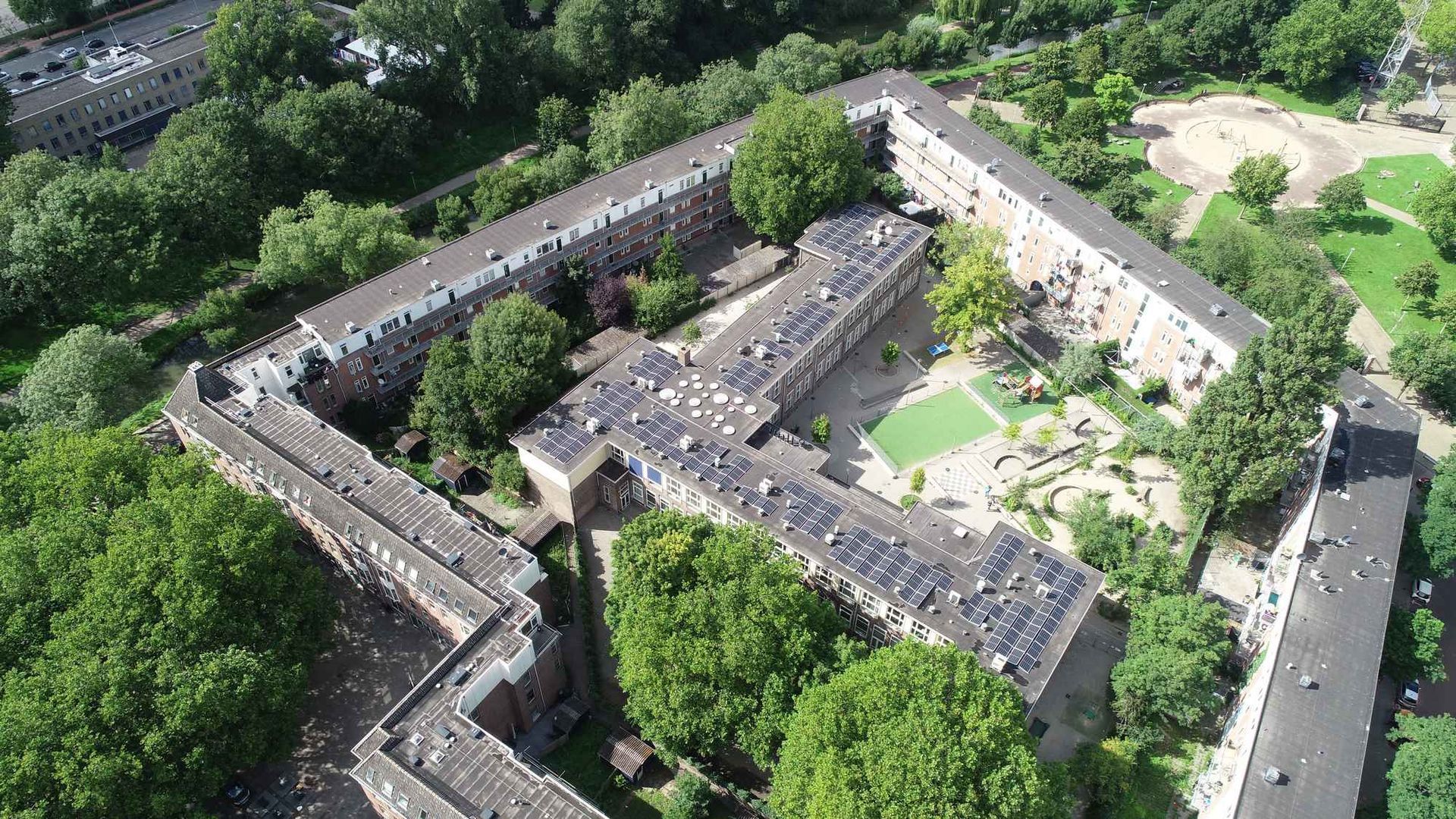 Een luchtfoto van een groot gebouw omgeven door bomen.