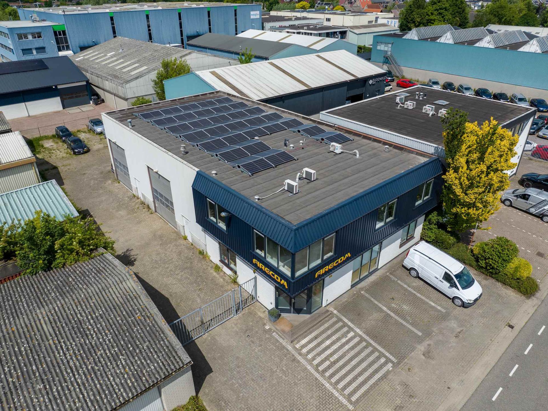 Een luchtfoto van een gebouw met zonnepanelen op het dak