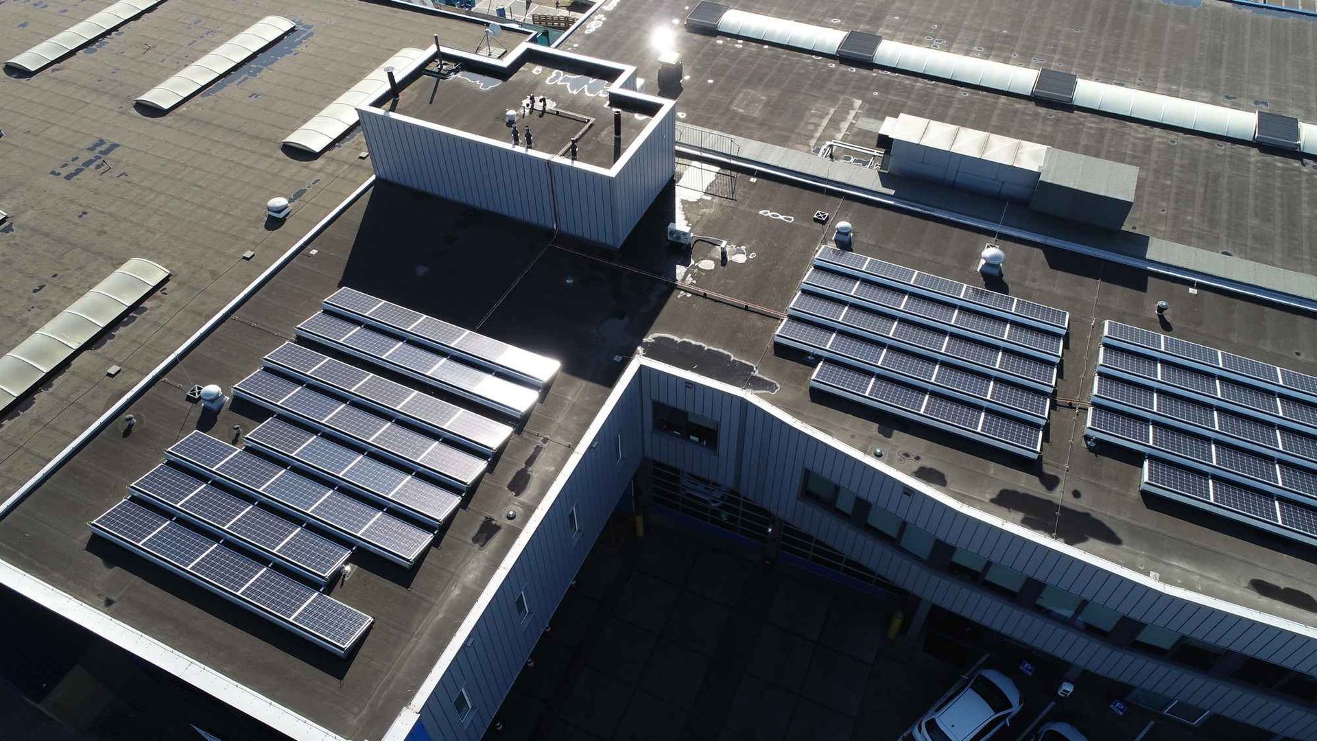 Een luchtfoto van een gebouw met zonnepanelen op het dak