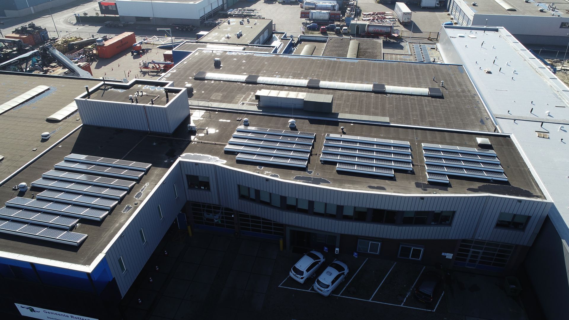 Een luchtfoto van een gebouw met zonnepanelen op het dak
