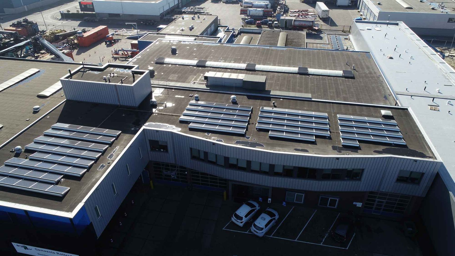 Een luchtfoto van een gebouw met zonnepanelen op het dak