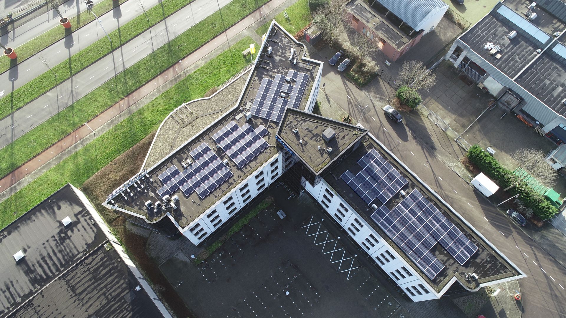 Een luchtfoto van een gebouw met zonnepanelen op het dak