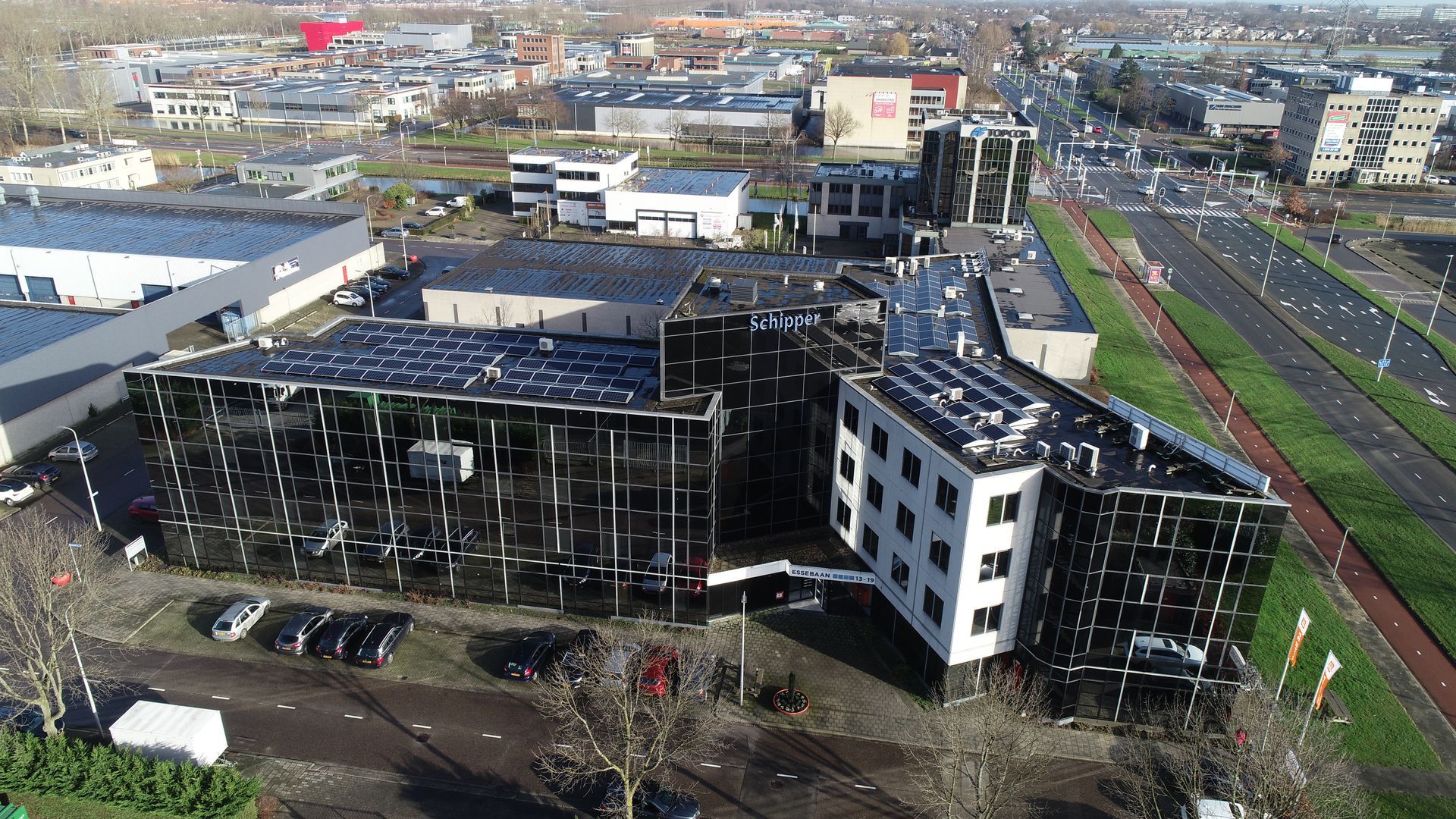 Een luchtfoto van een groot gebouw met zonnepanelen op het dak.