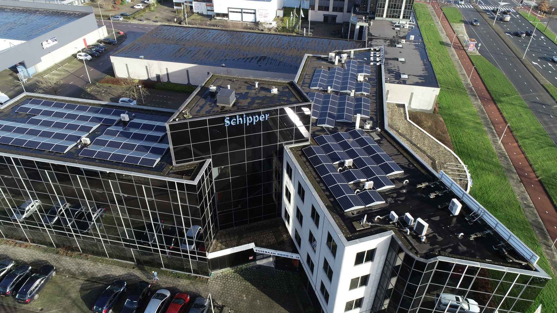 Een luchtfoto van een gebouw met zonnepanelen op het dak
