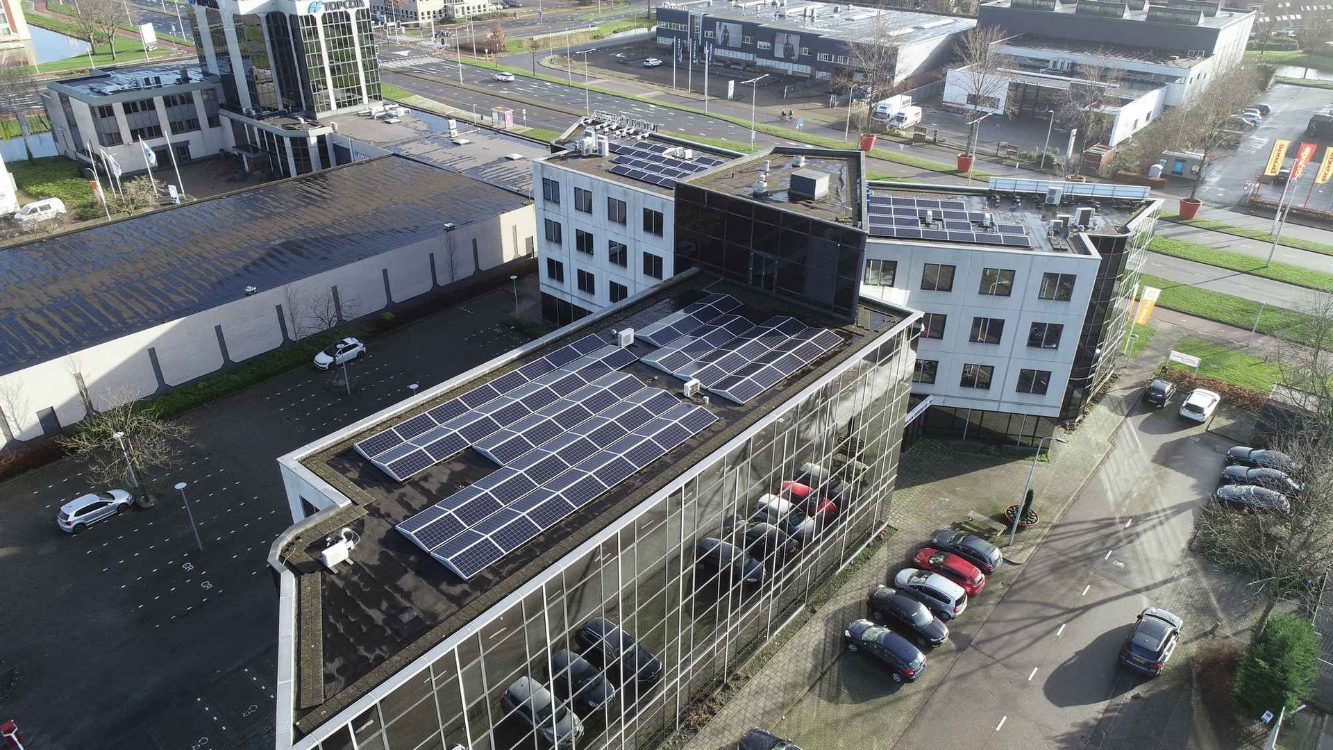 Een luchtfoto van een gebouw met zonnepanelen op het dak.