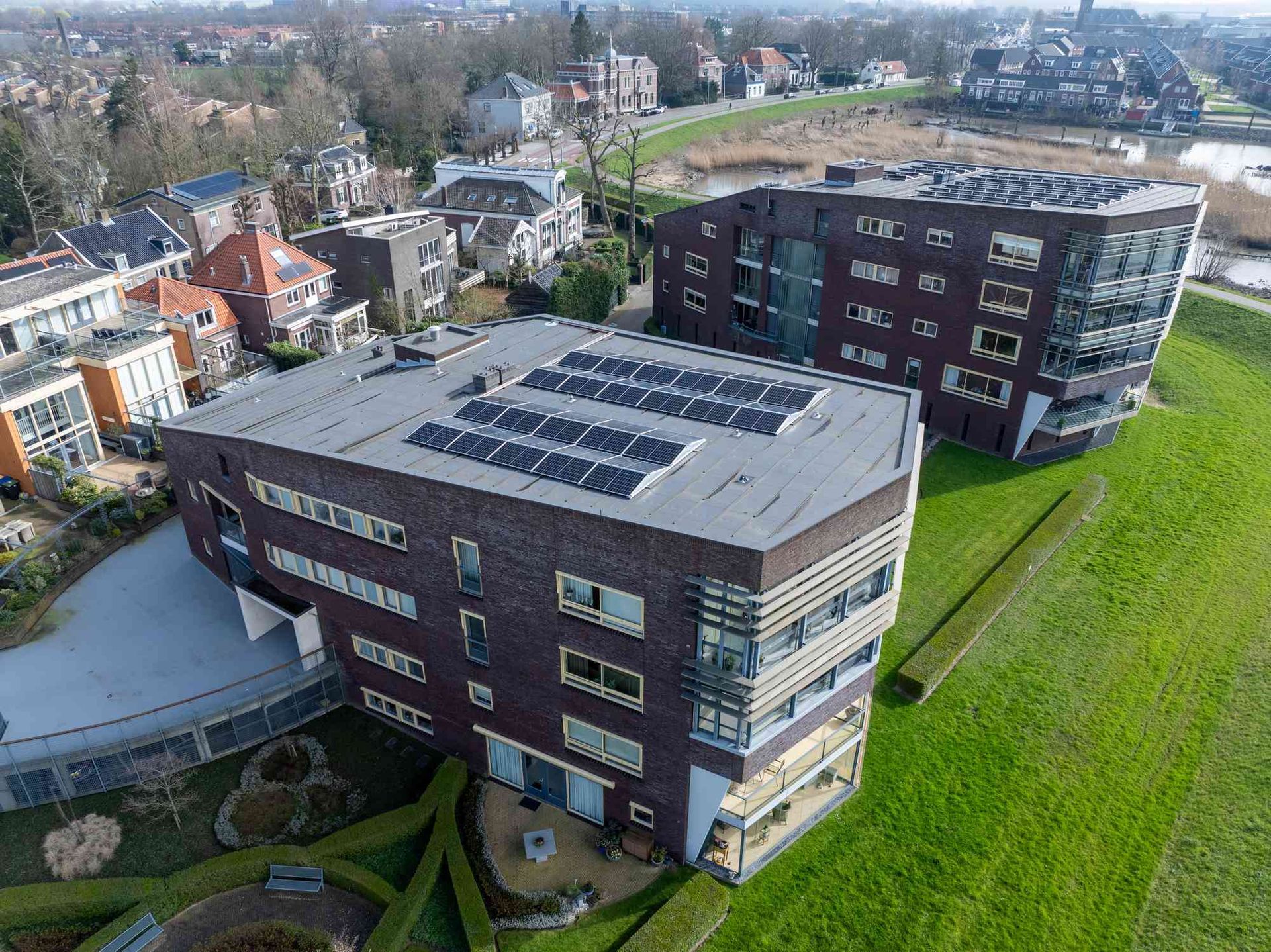 Een luchtfoto van een groot gebouw met zonnepanelen op het dak.