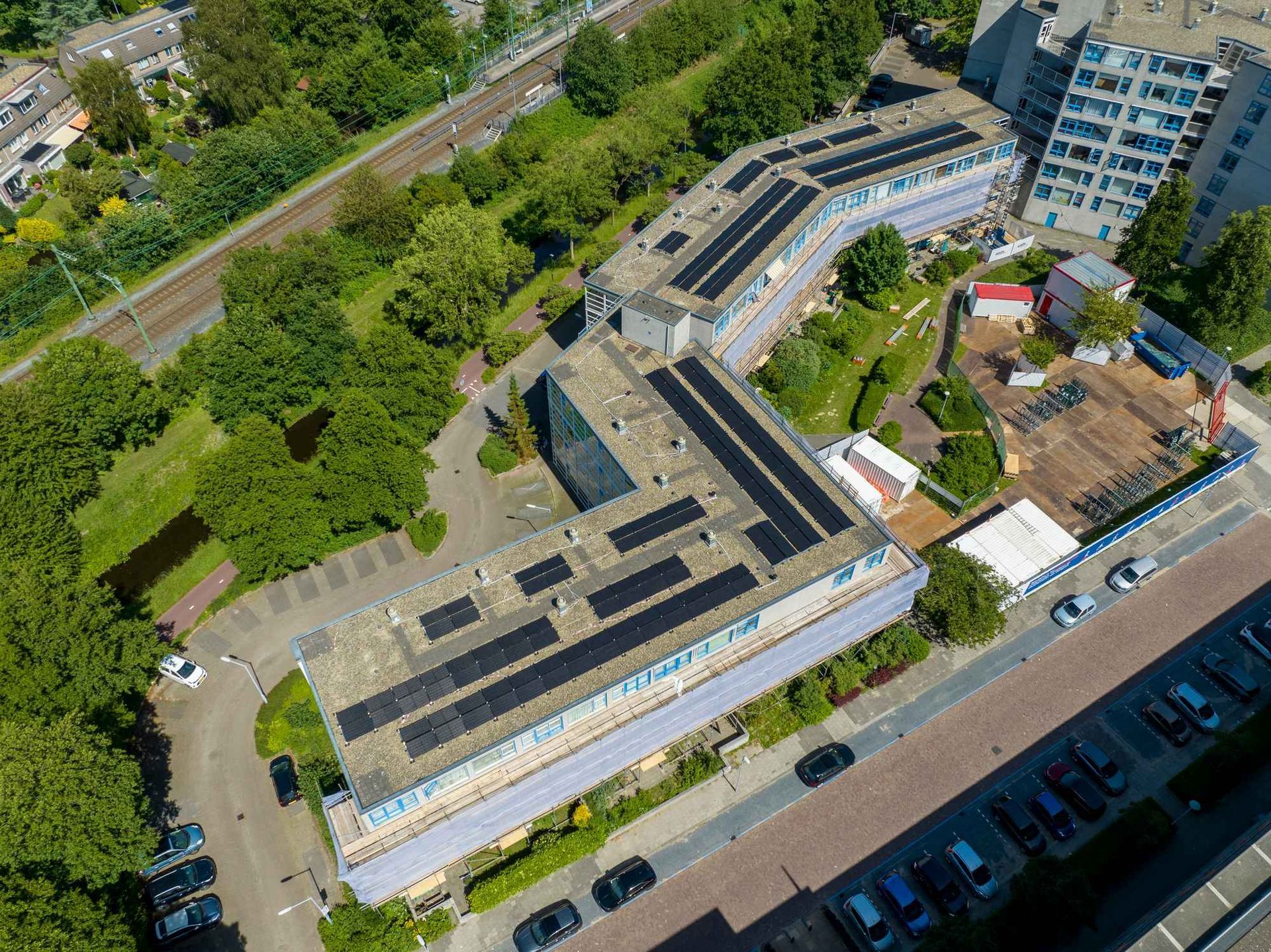 Een luchtfoto van een groot gebouw met zonnepanelen op het dak.