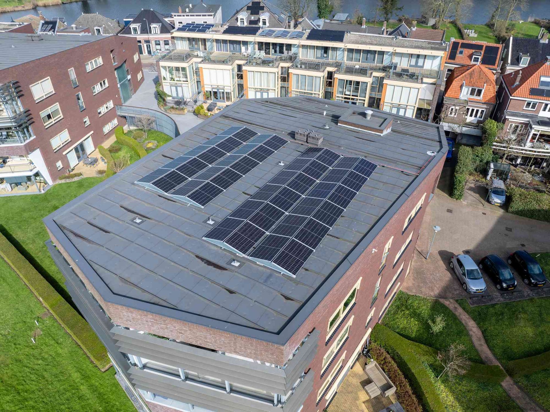 Een luchtfoto van een gebouw met zonnepanelen op het dak.