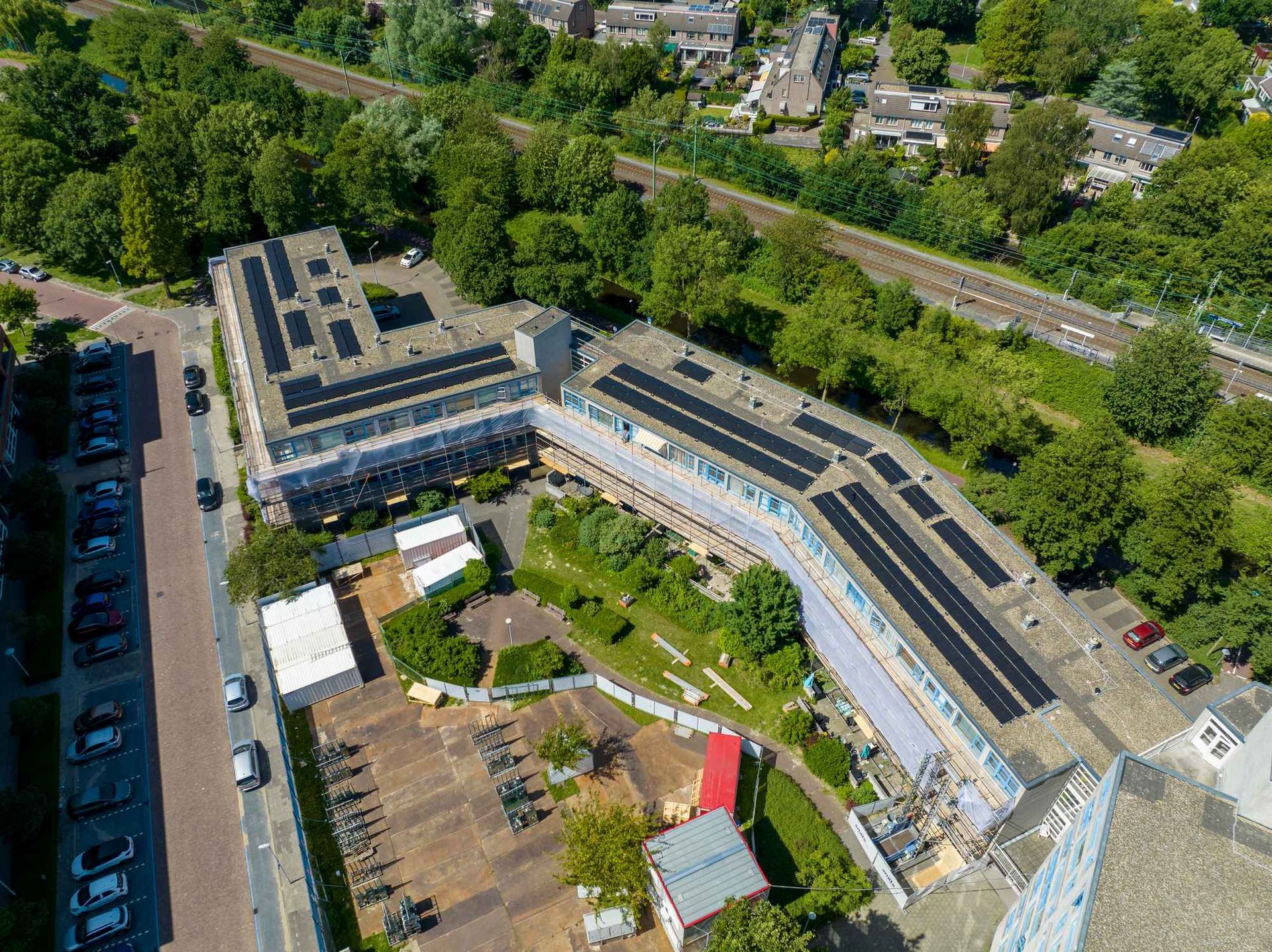 Een luchtfoto van een gebouw met zonnepanelen op het dak.