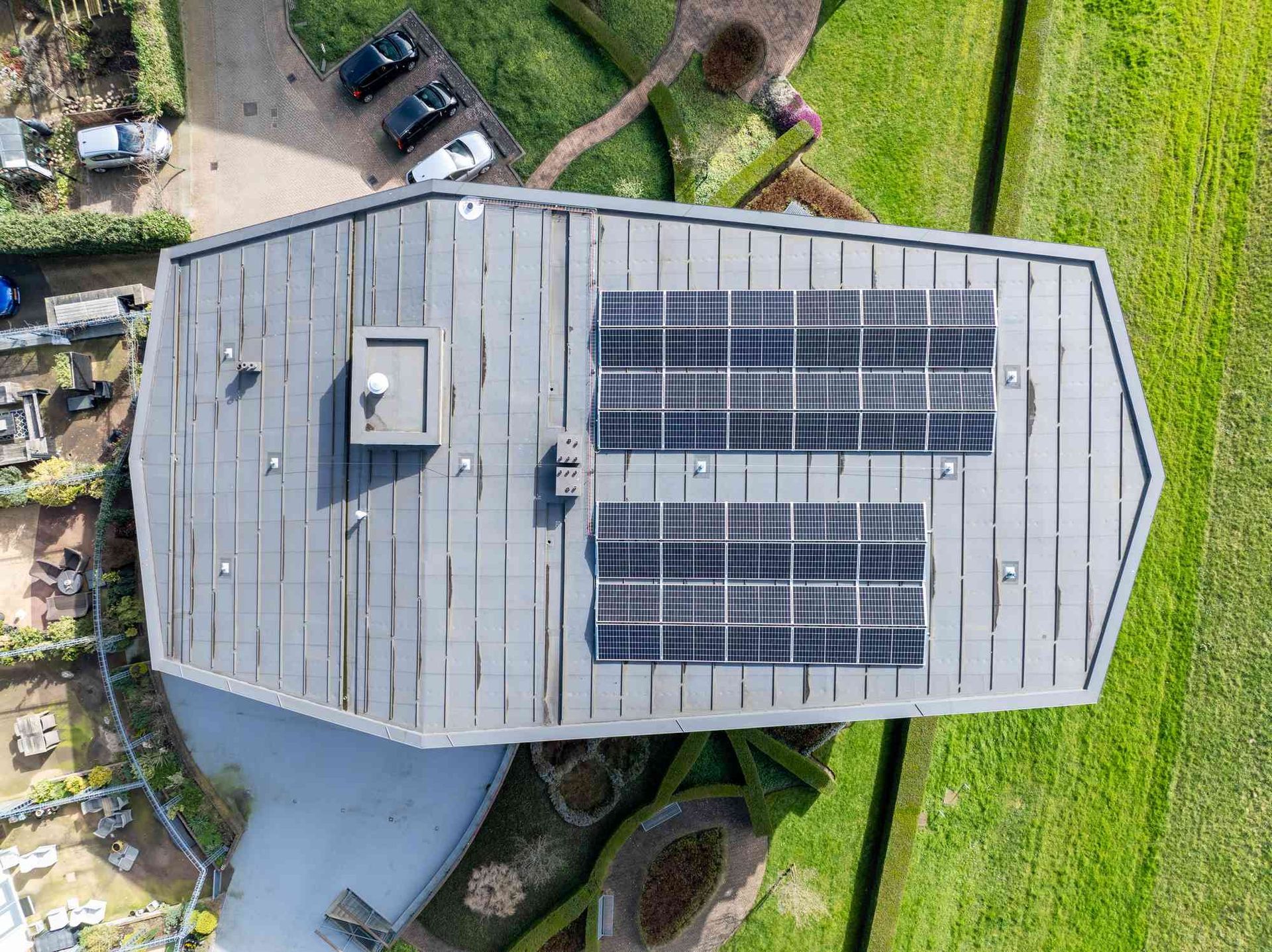 Een luchtfoto van een gebouw met zonnepanelen op het dak.