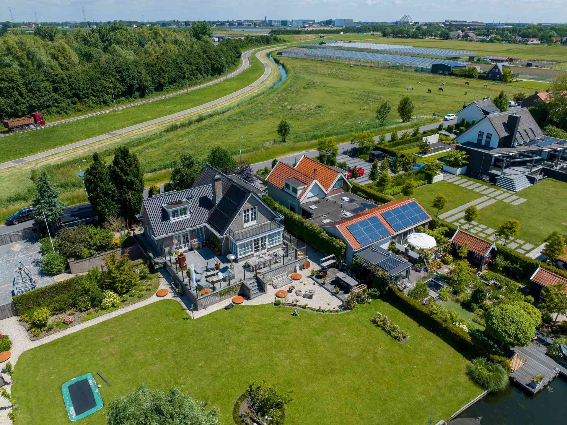 Een luchtfoto van een huis midden in een weelderig groen veld.