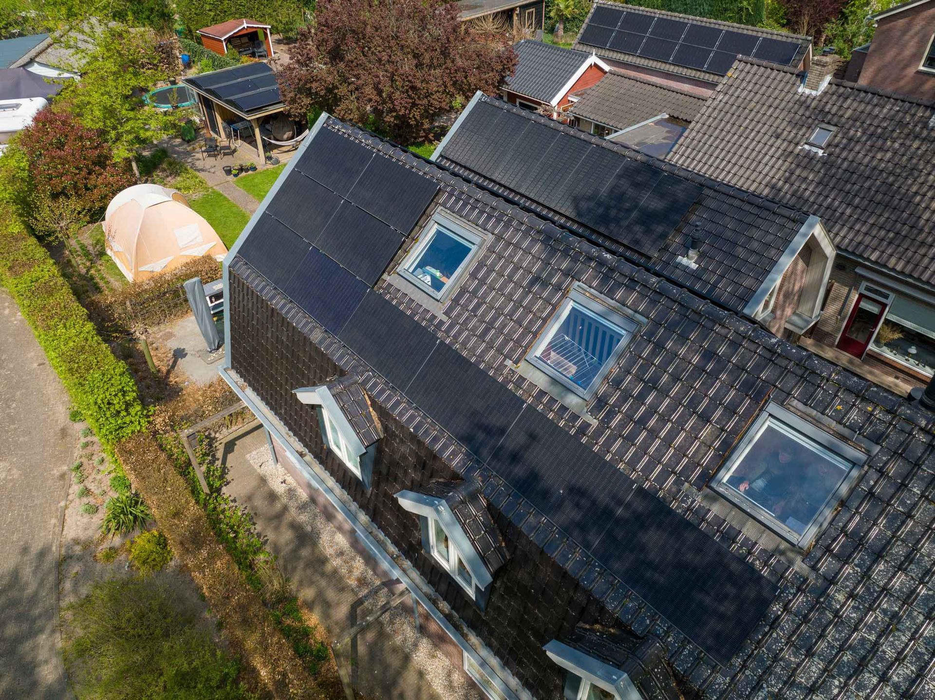 Een luchtfoto van een huis met zonnepanelen op het dak.