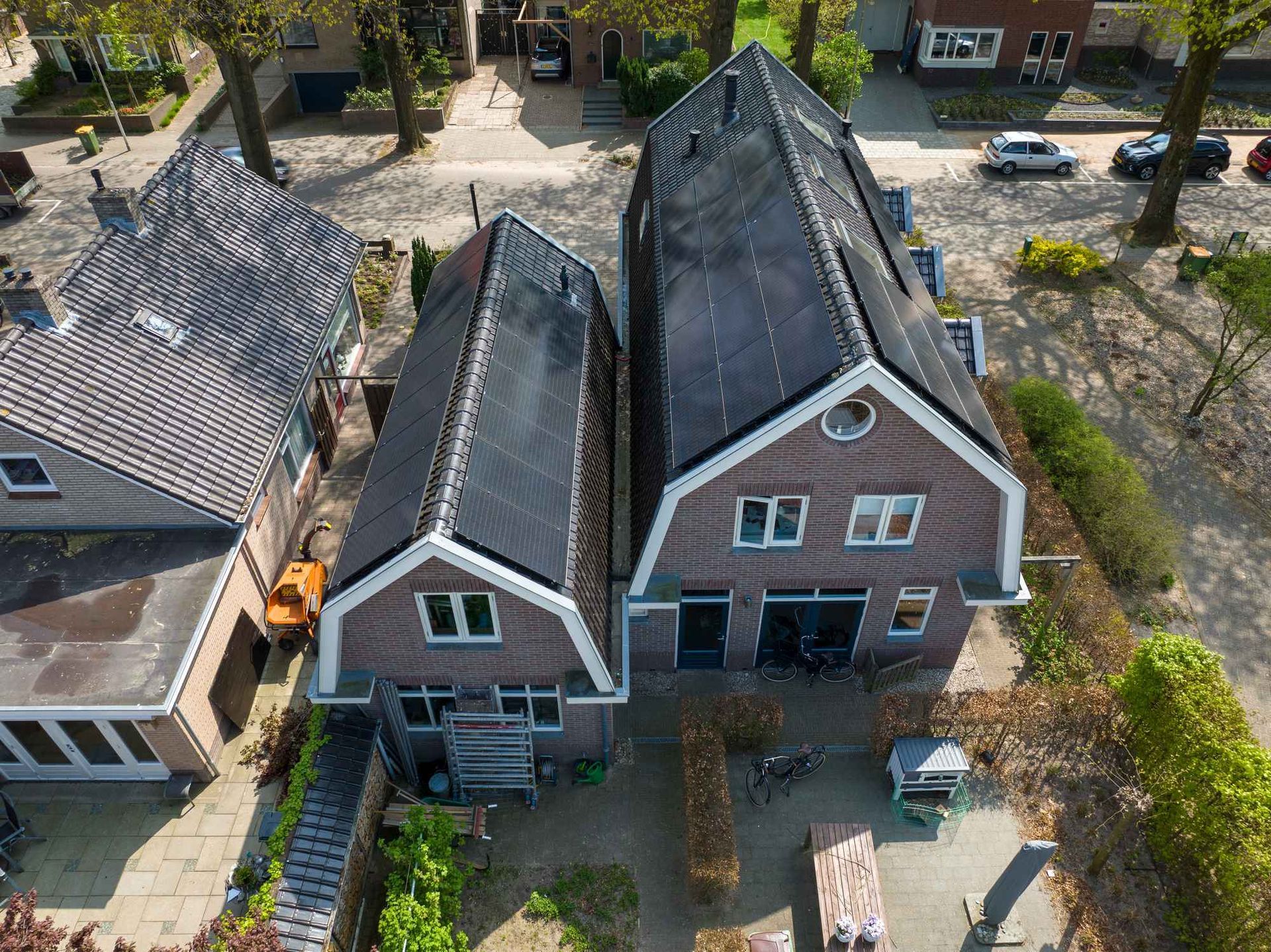 Een luchtfoto van een bakstenen huis met een zwart dak